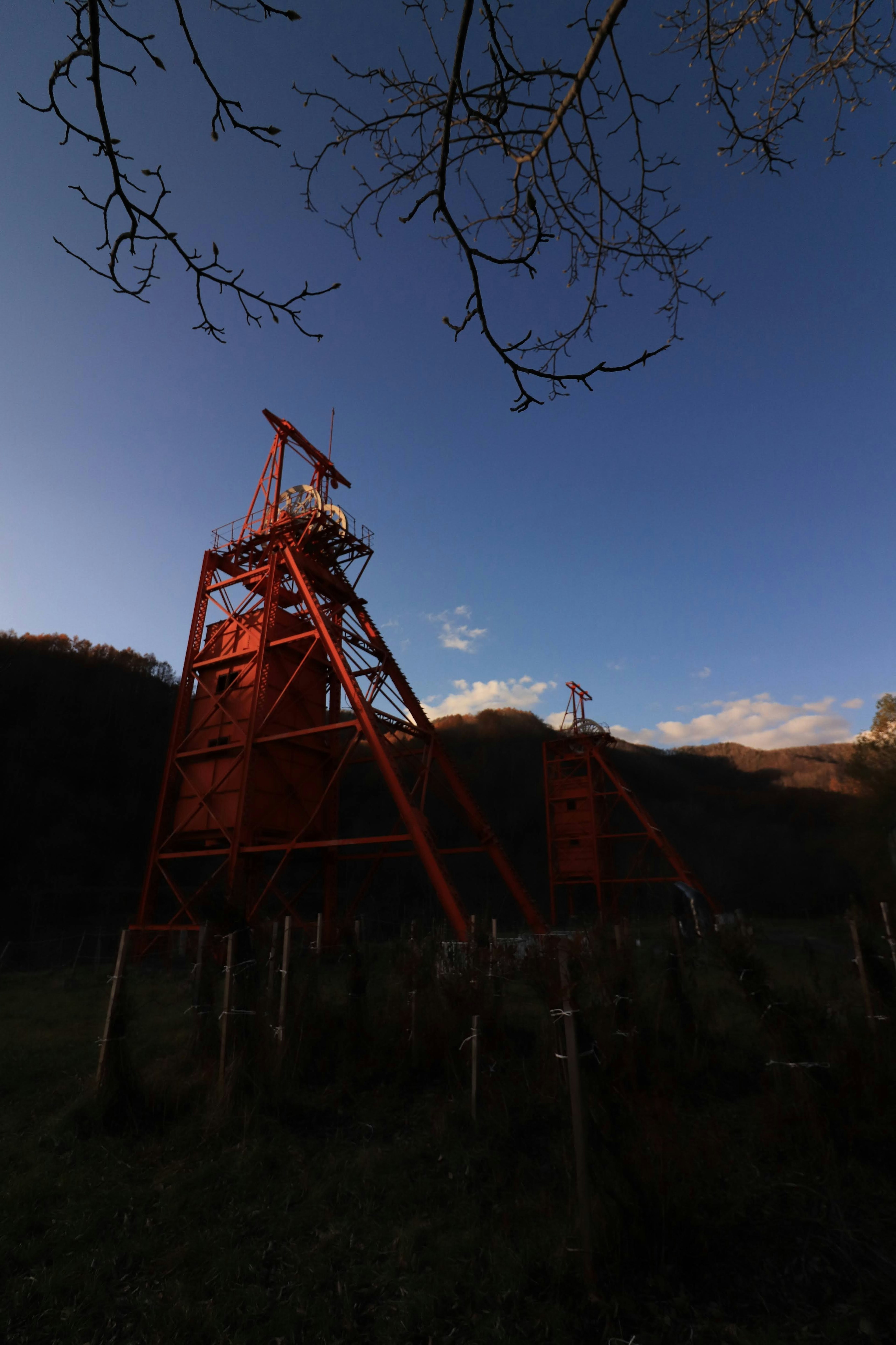 Orange mining rig at dusk with mountains in the background