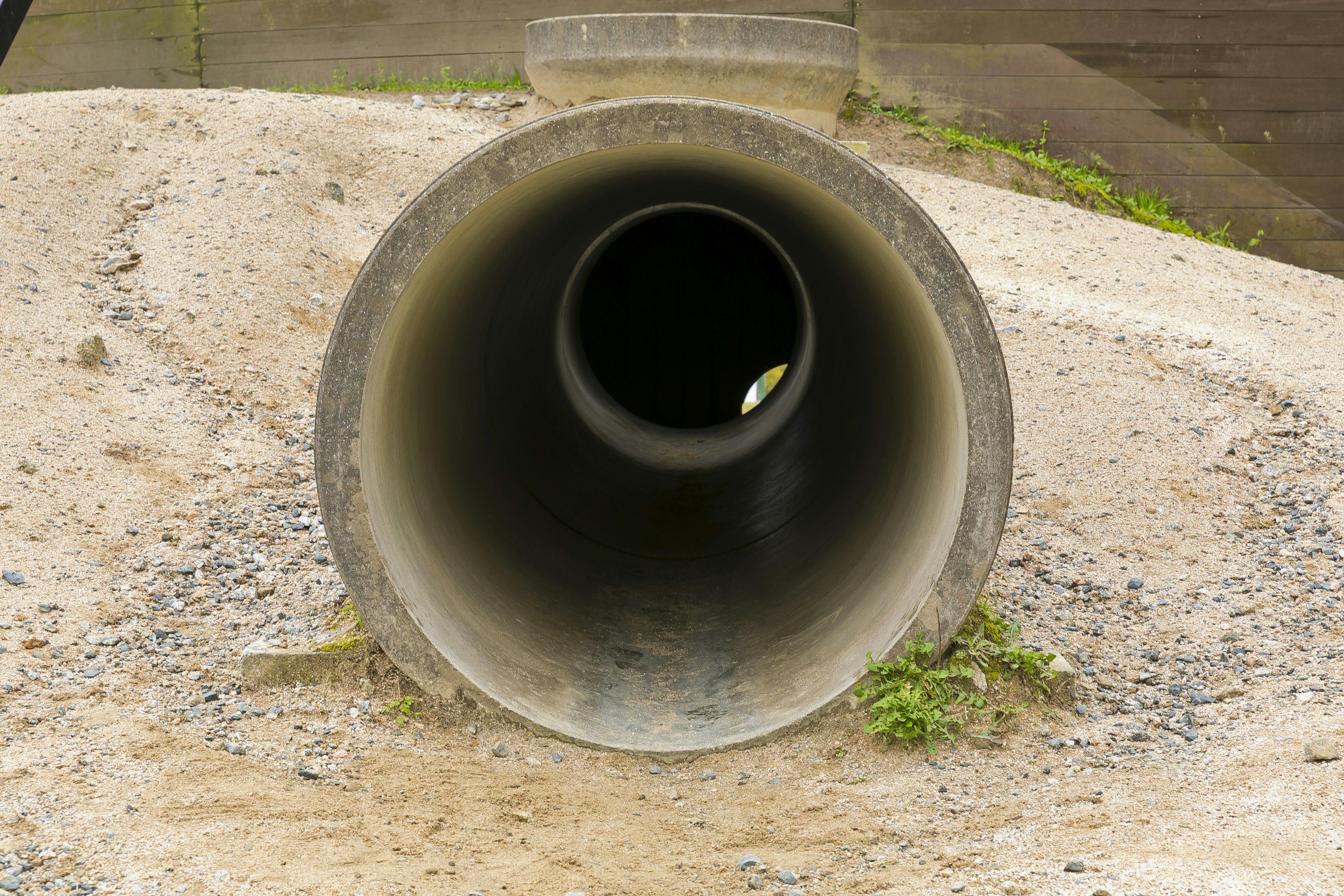 Imagen de un tubo de concreto sobre grava con apertura visible