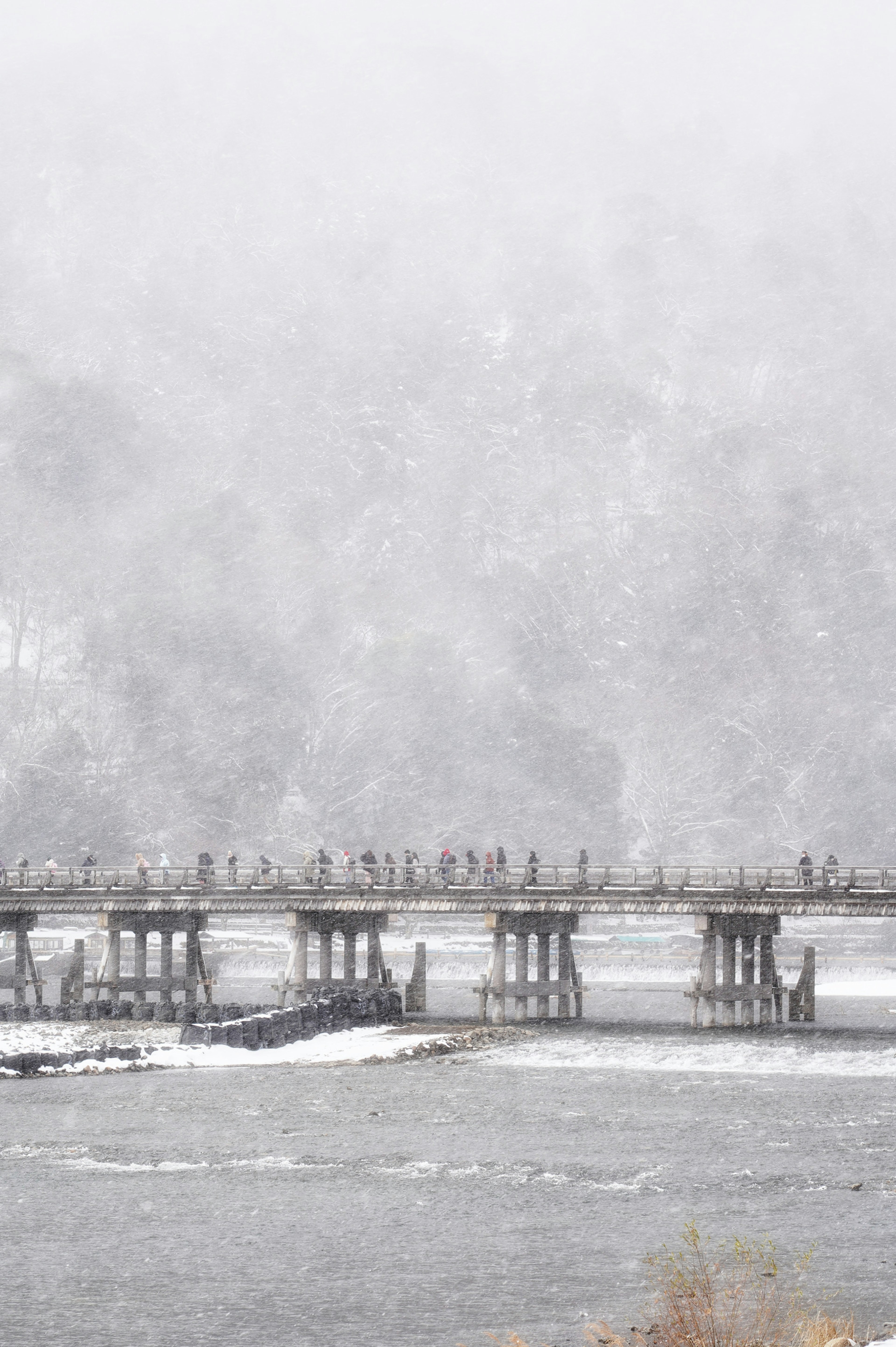 Snow-covered bridge in a foggy landscape