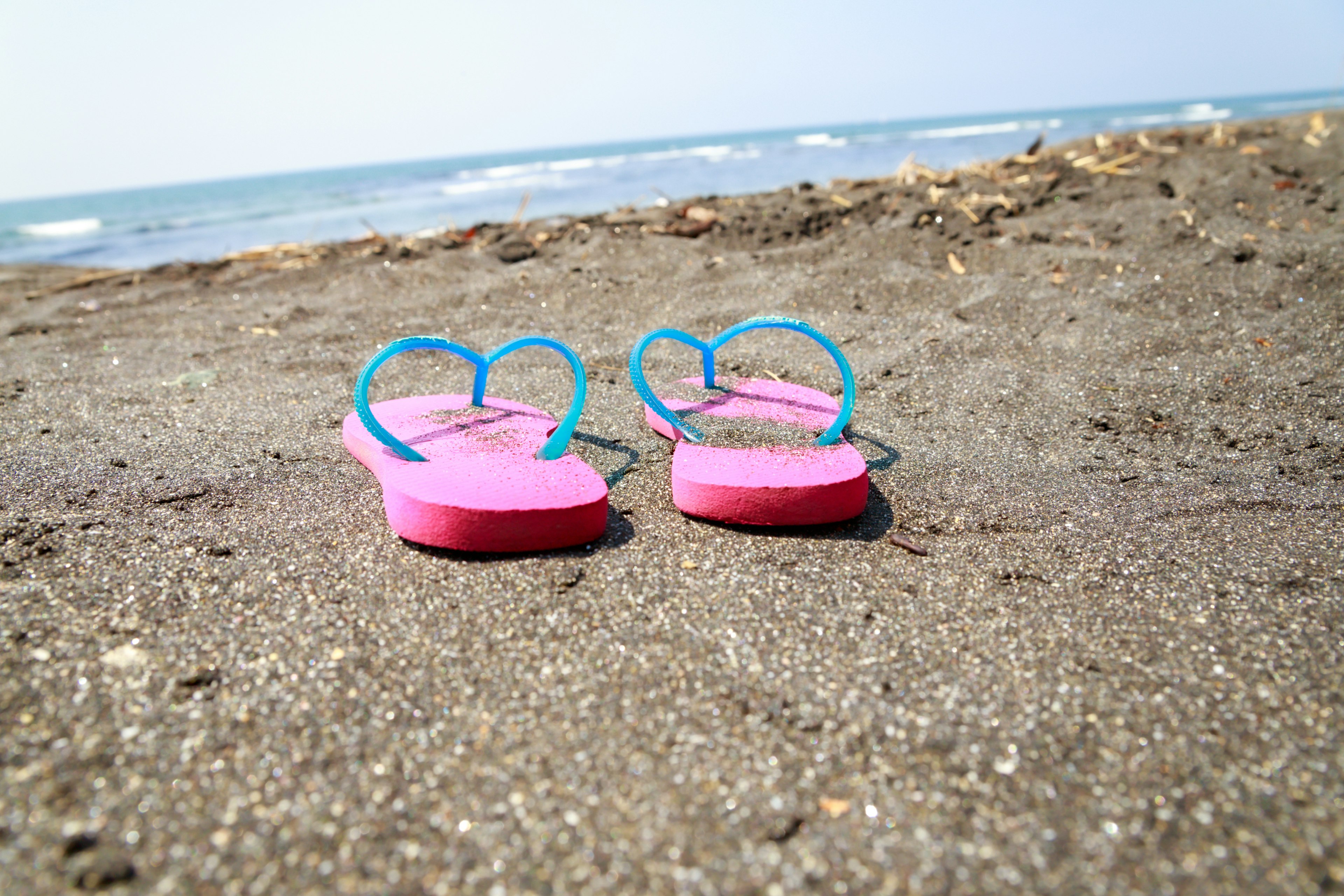 Infradito a forma di cuore sulla spiaggia