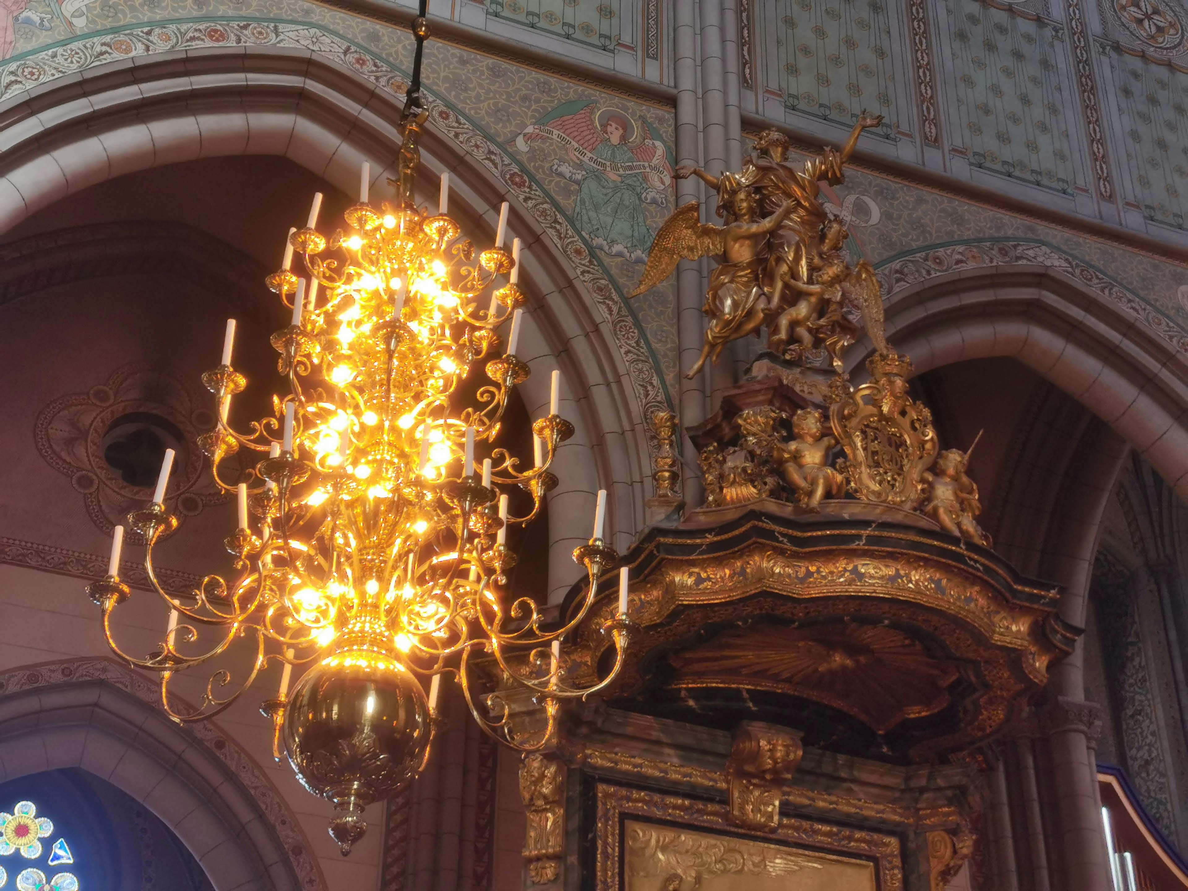 Interior gereja dengan chandelier hias dan altar yang dihias