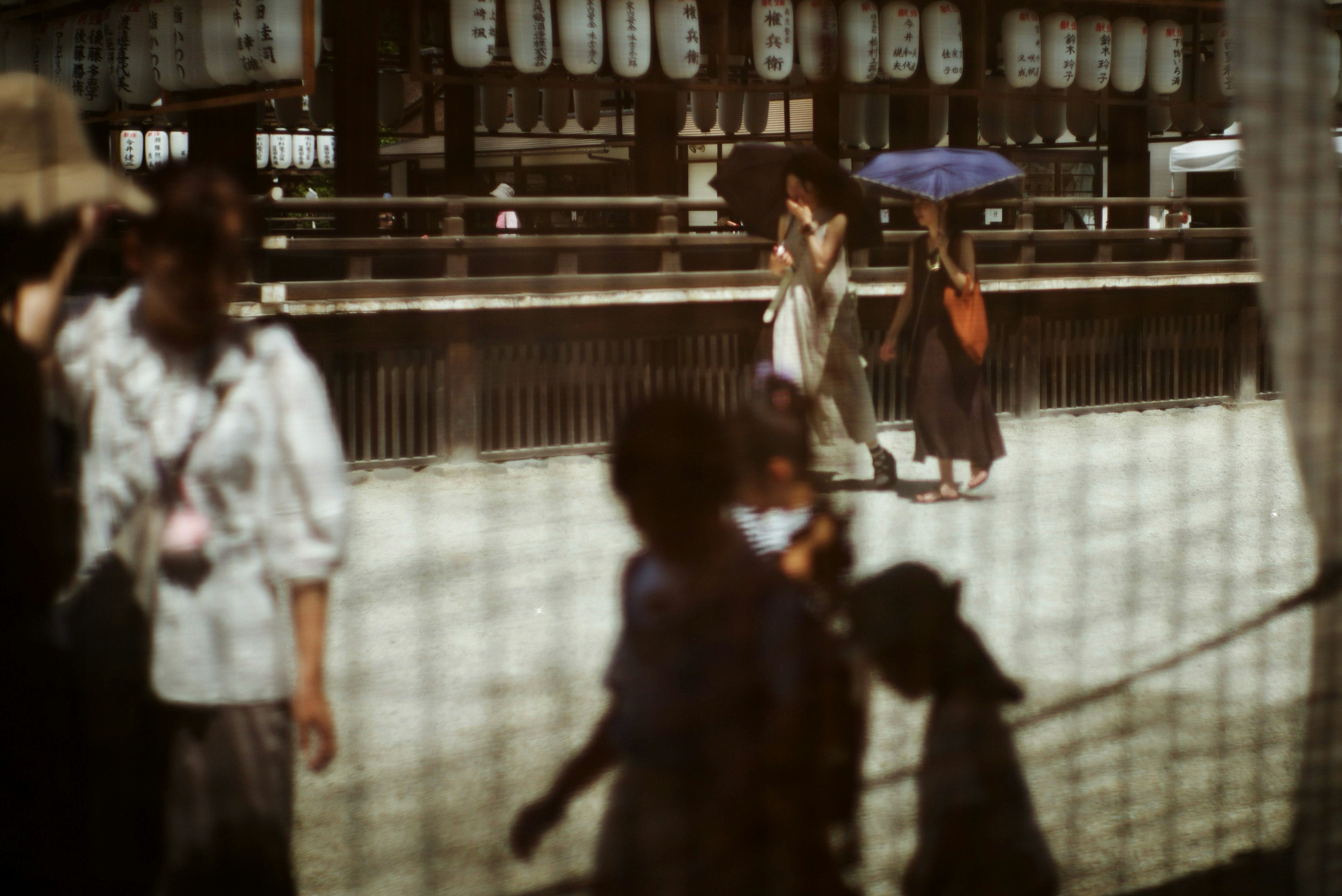 Imagen que captura personas caminando en un fondo débilmente iluminado