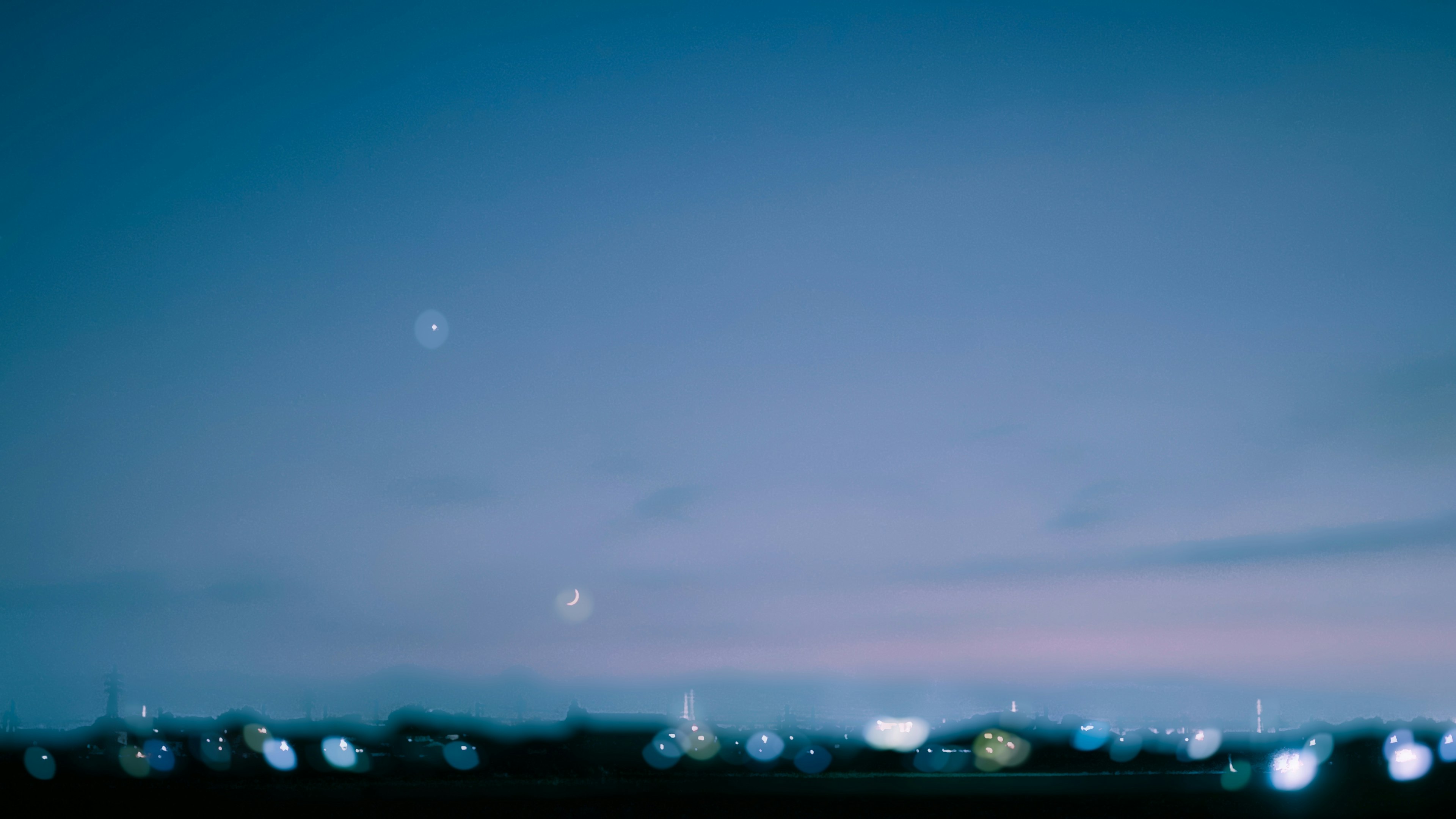 ぼやけた夜空と都市の明かりが映る風景