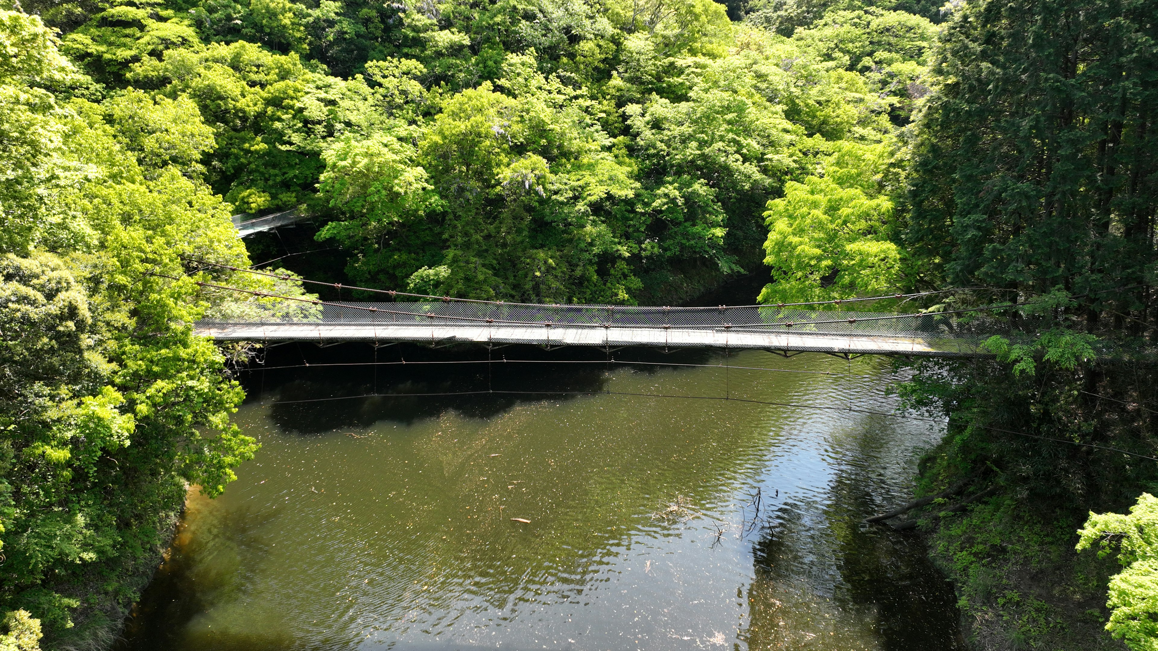 Brücke über einen Fluss, umgeben von üppigem Grün und Bäumen