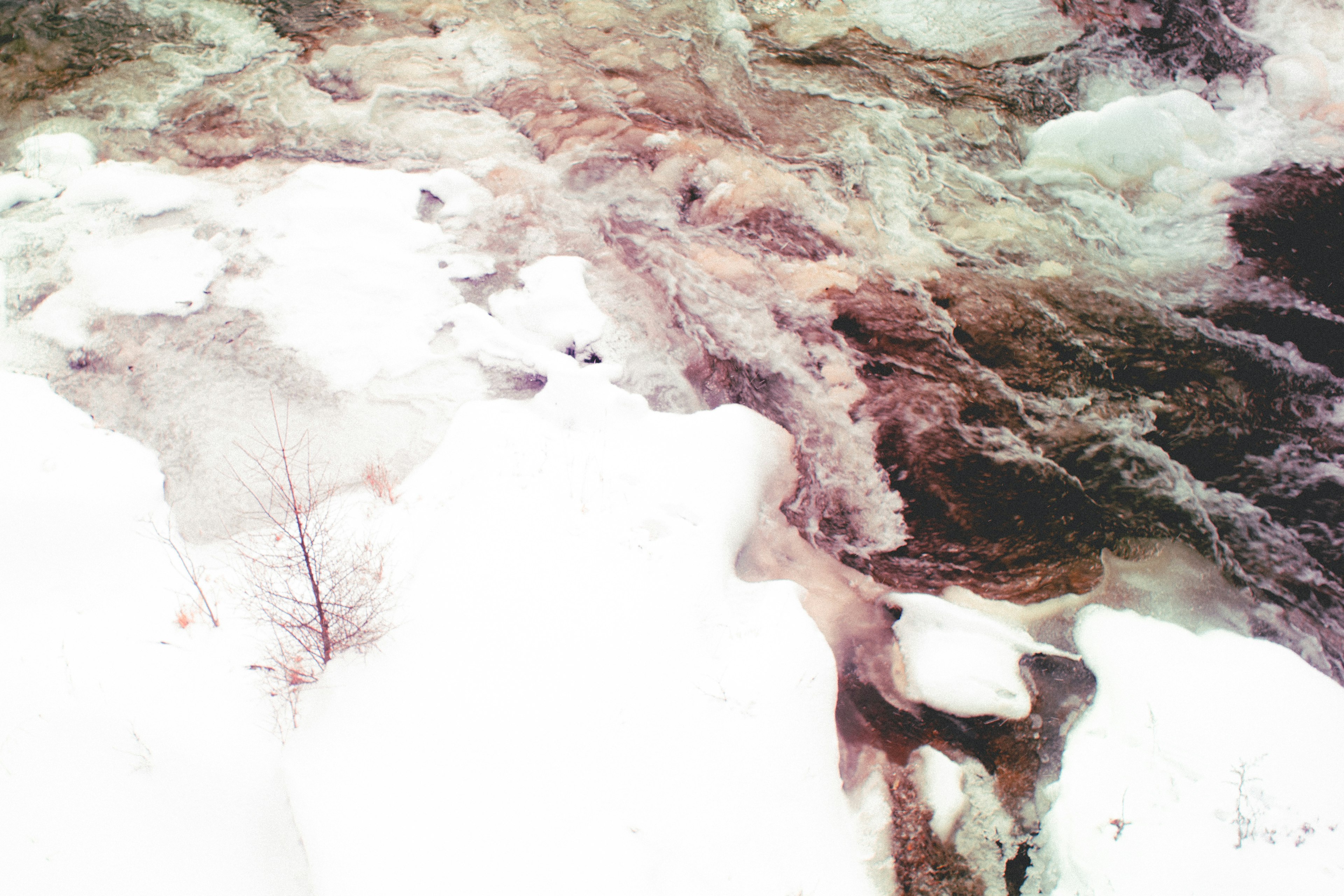 Vista di un fiume con acqua che scorre e ghiaccio coperto di neve