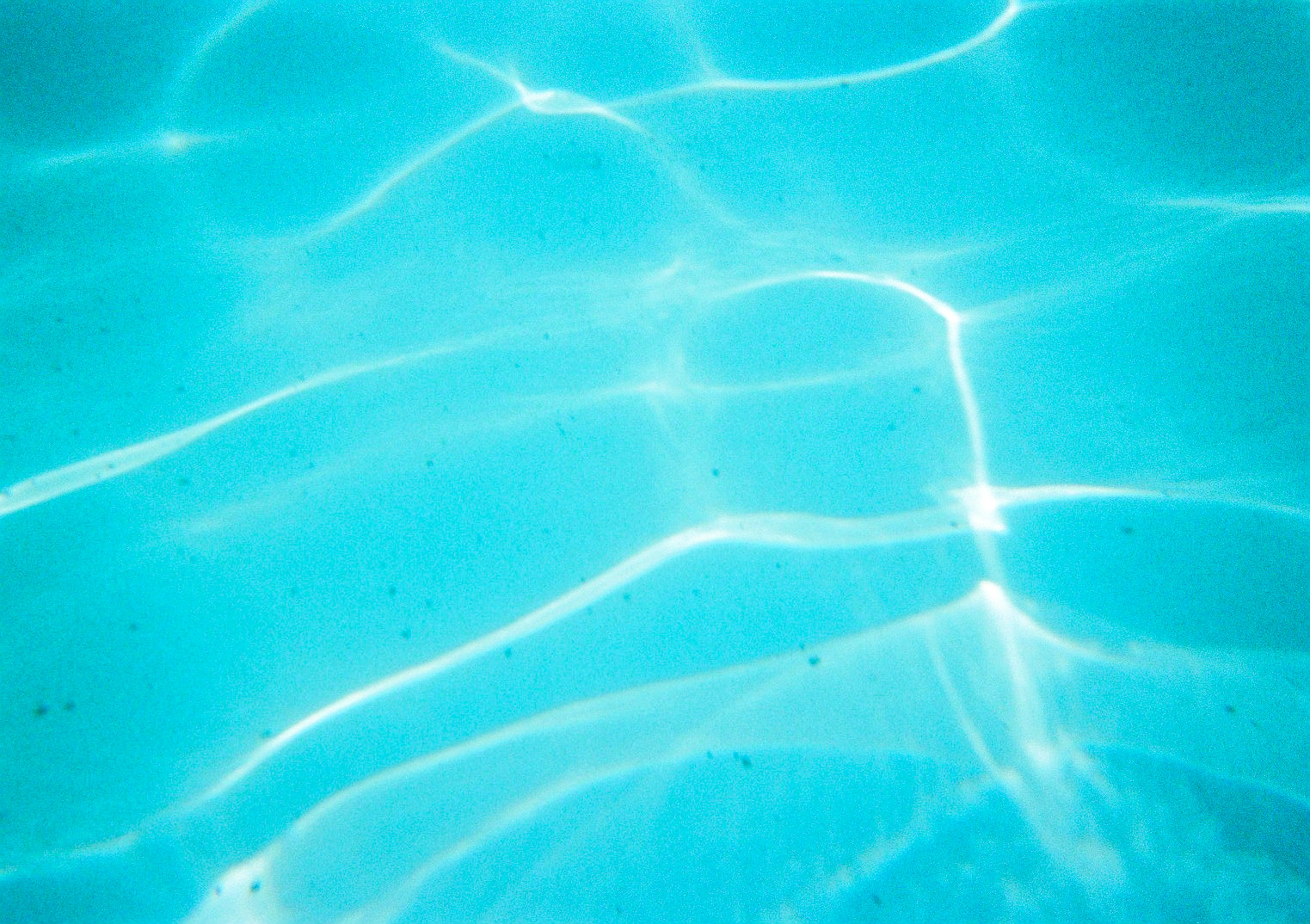 Blue water surface with ripples and light reflections