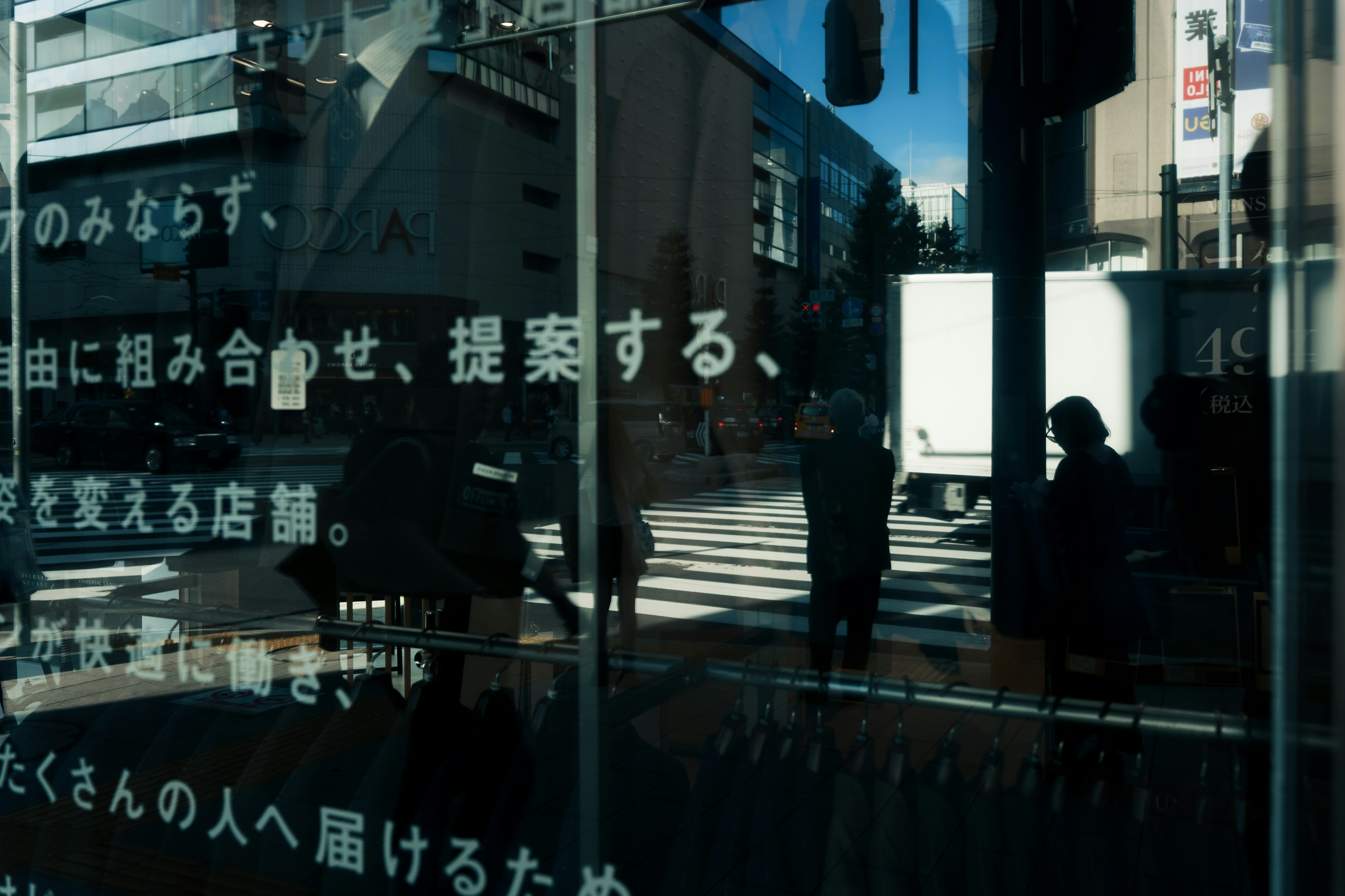 Reflections of city scenery and silhouettes of people on glass