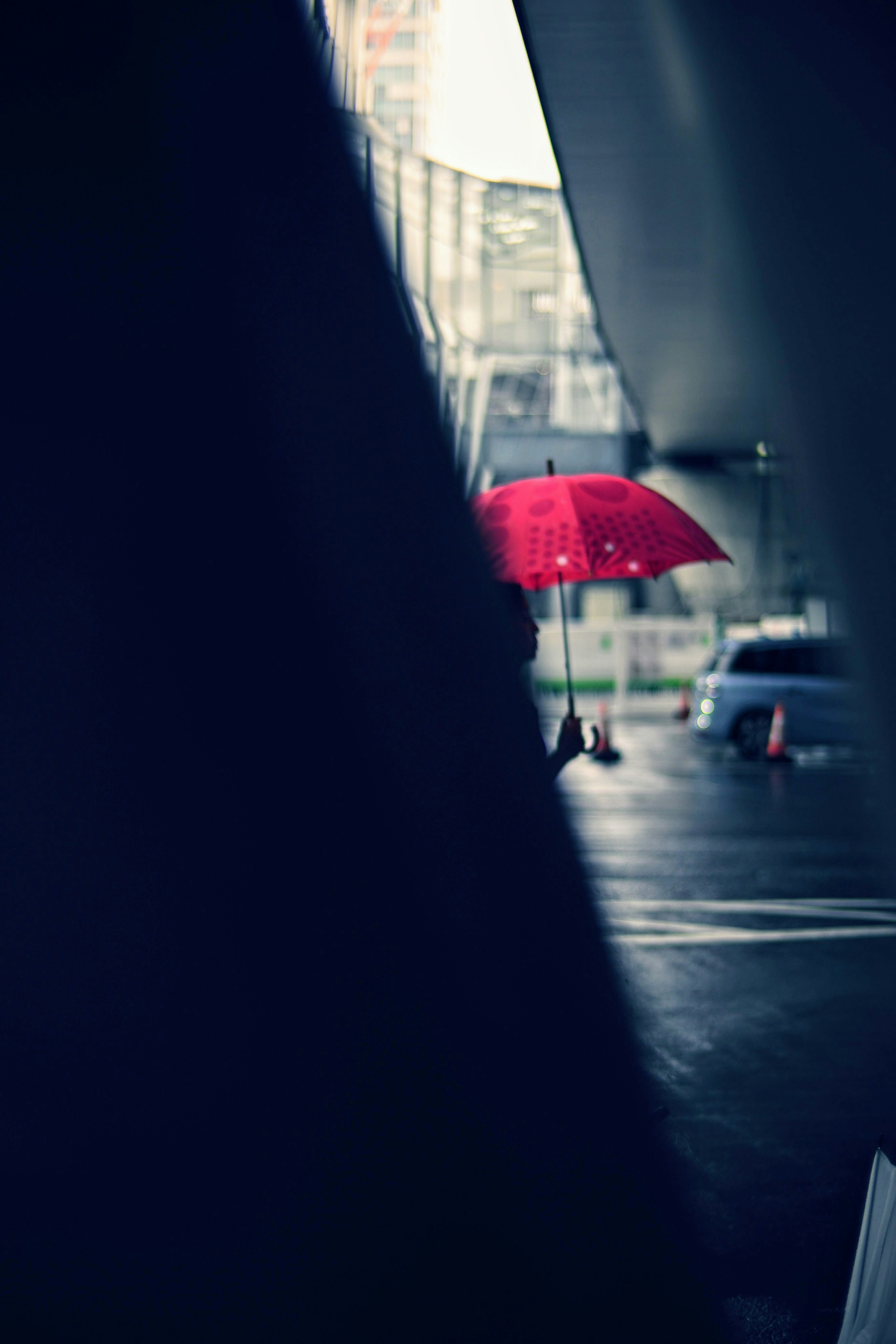 Una persona con un ombrello rosso in un contesto urbano