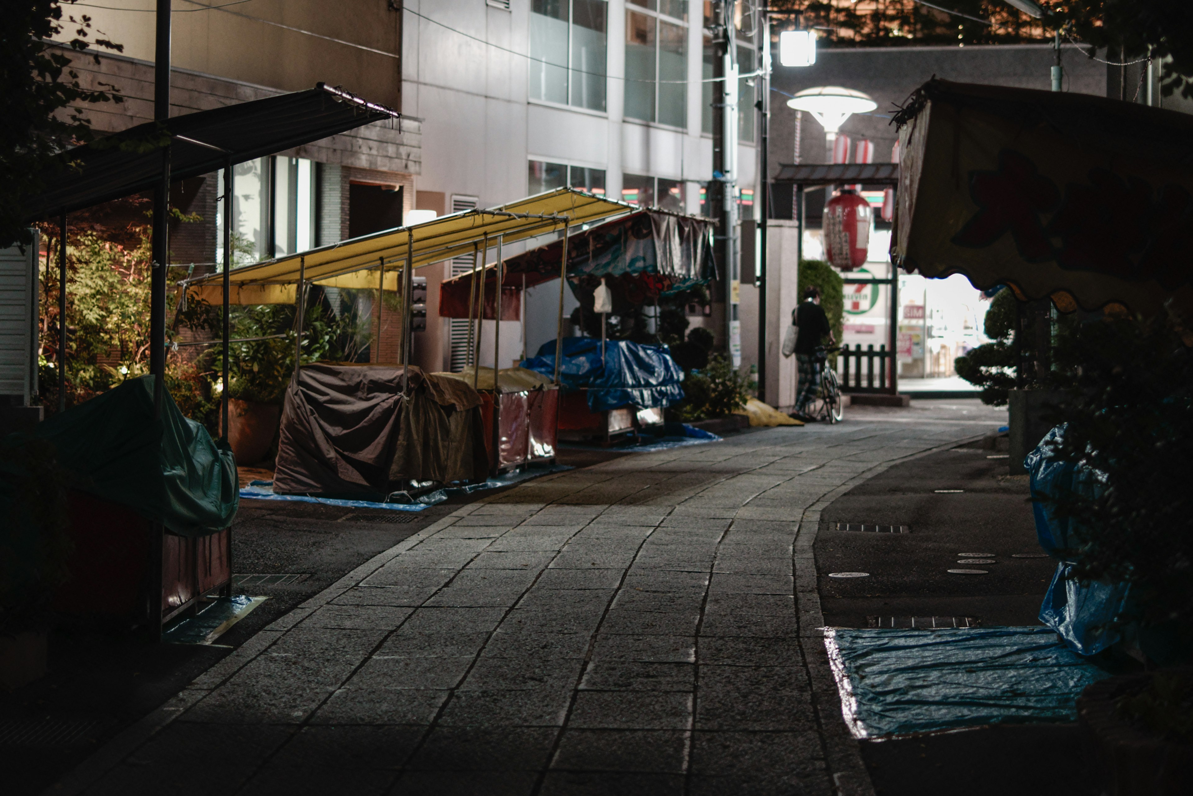 Escena nocturna de puestos y carpas en un callejón