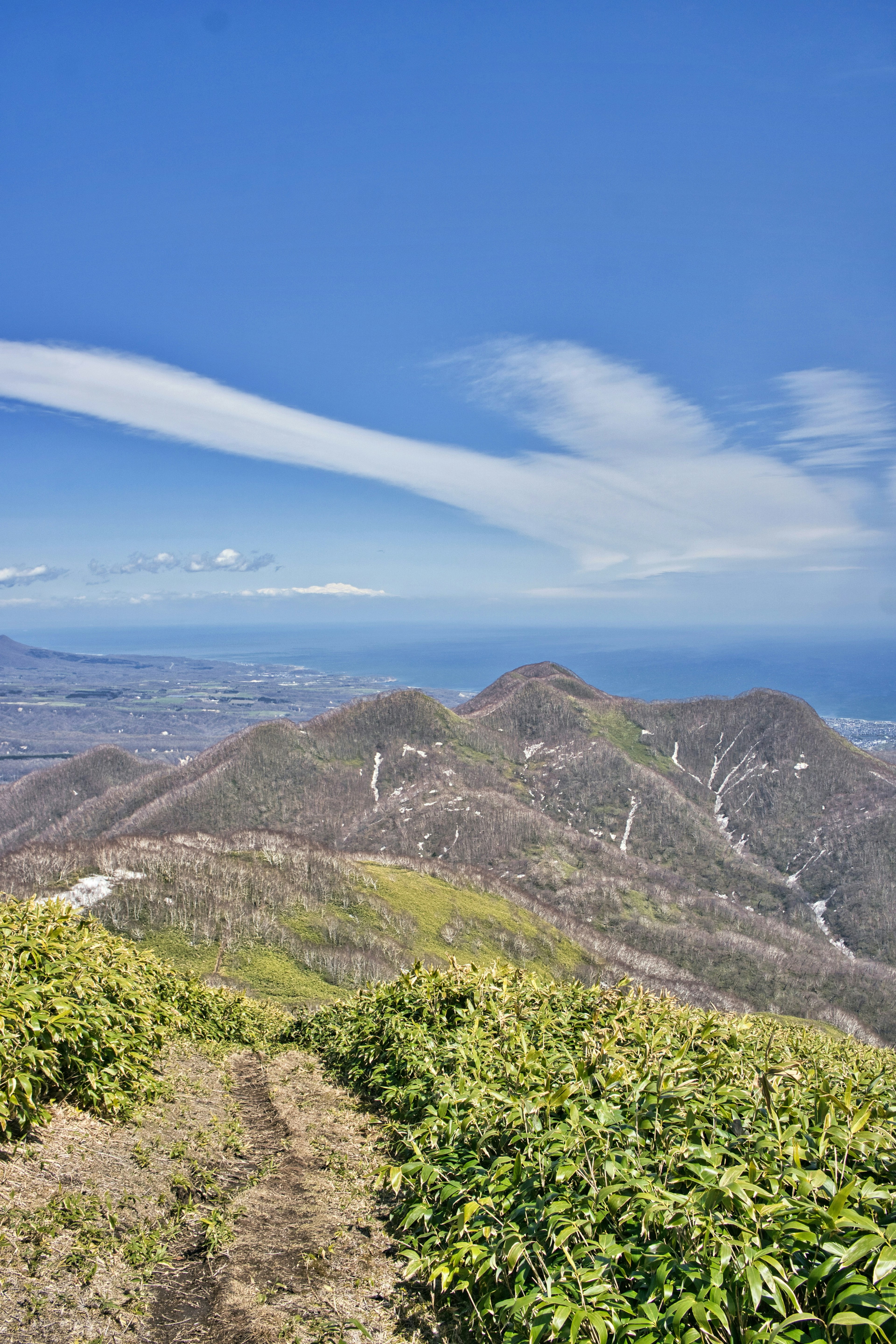 Malersicher Blick auf Berge und Ozean unter blauem Himmel