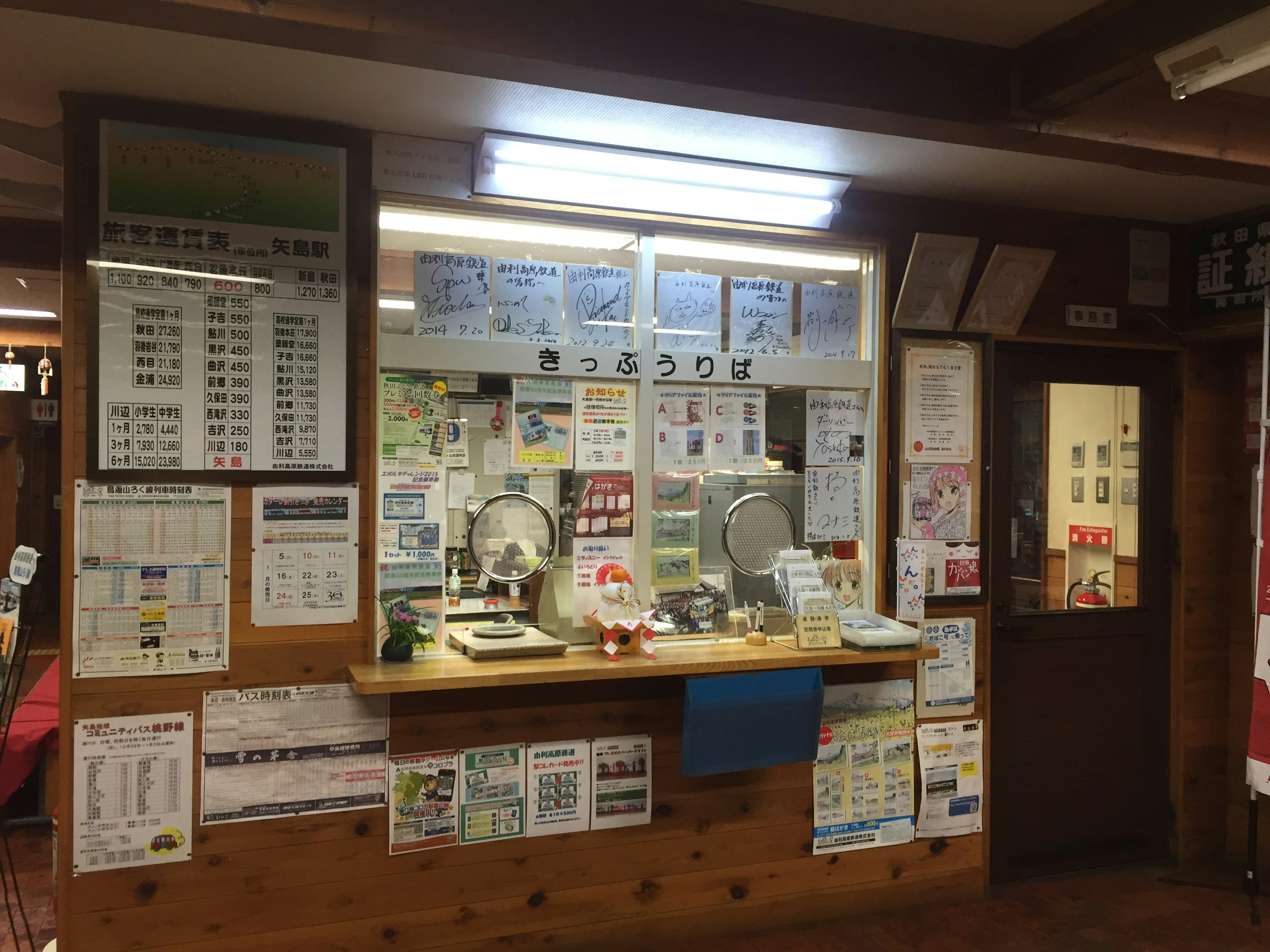 Interior of a counter with wooden walls and windows featuring various notices and documents