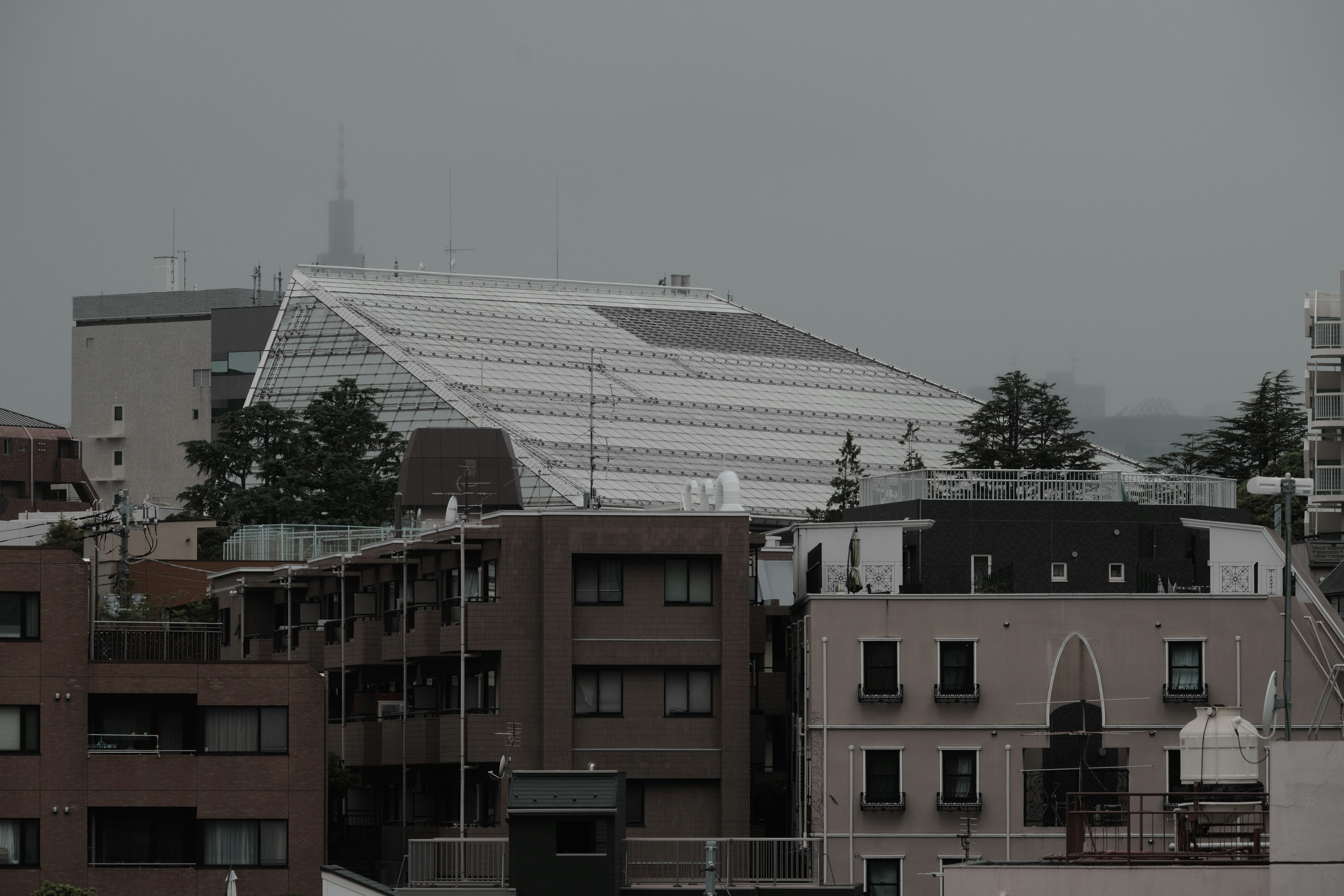 Stadtgebäude unter einem grauen Himmel mit einer Glasdachstruktur