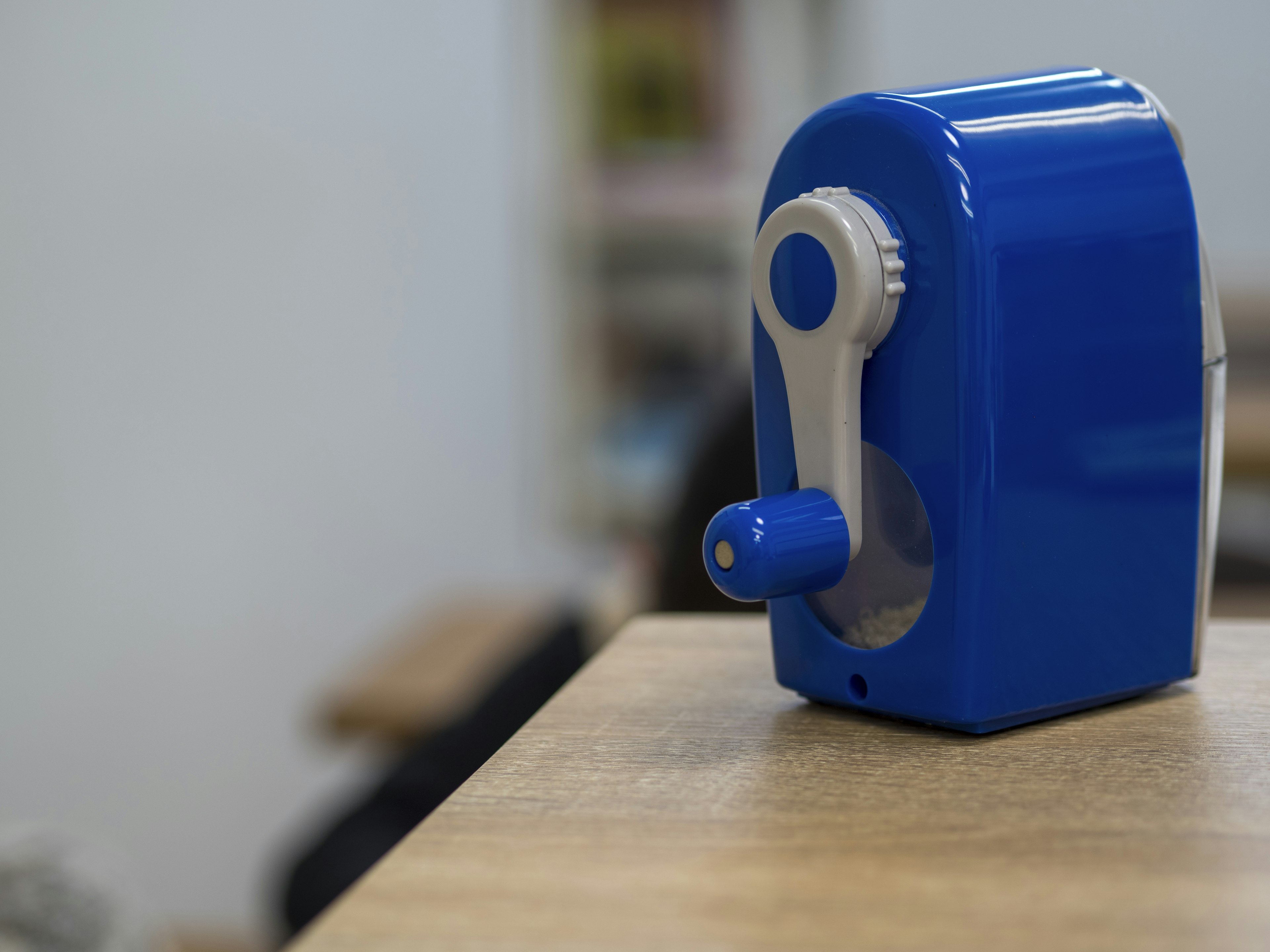 Taille-crayon bleu posé sur une table en bois