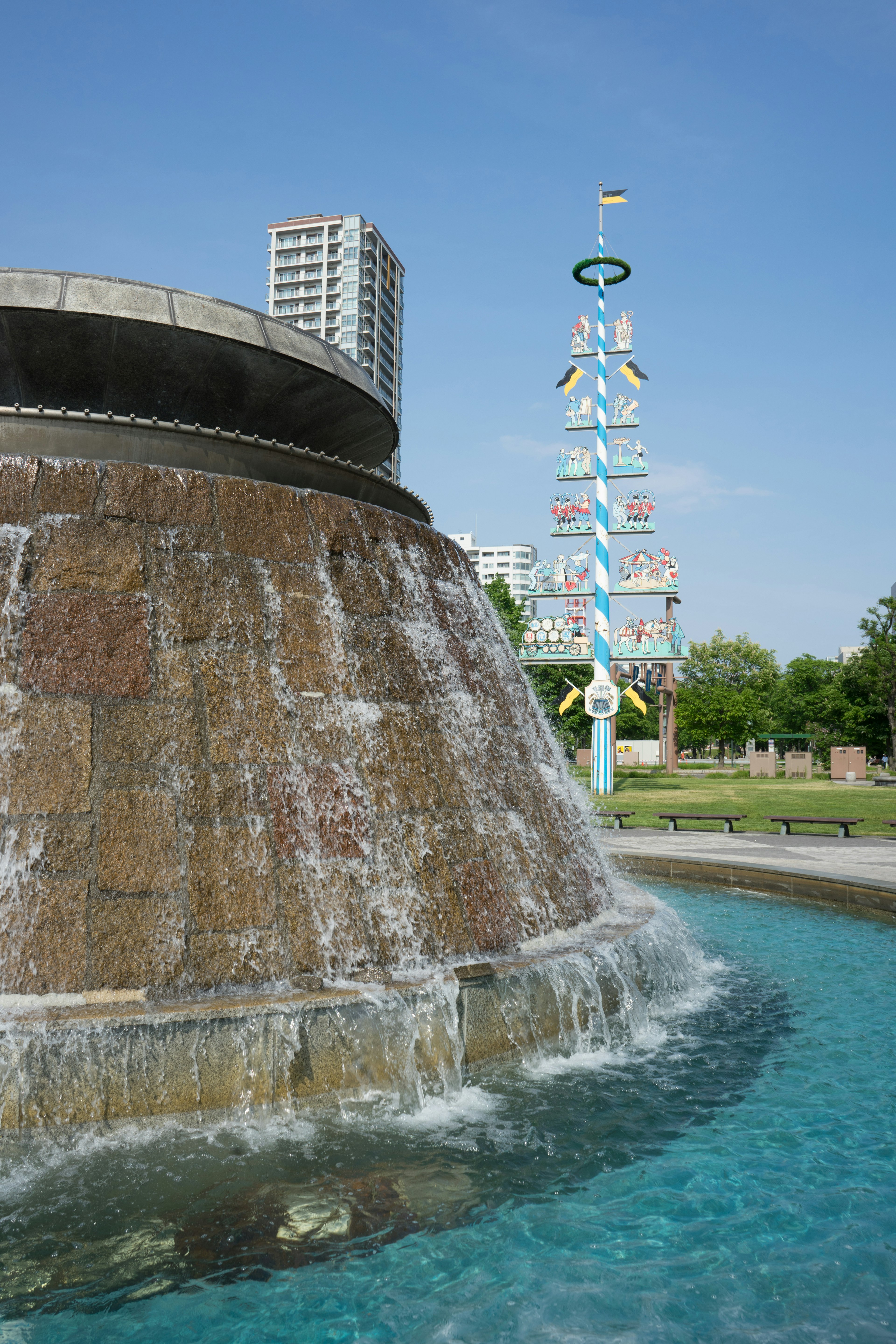 Parkbrunnen mit fließendem Wasser und blauem Himmel