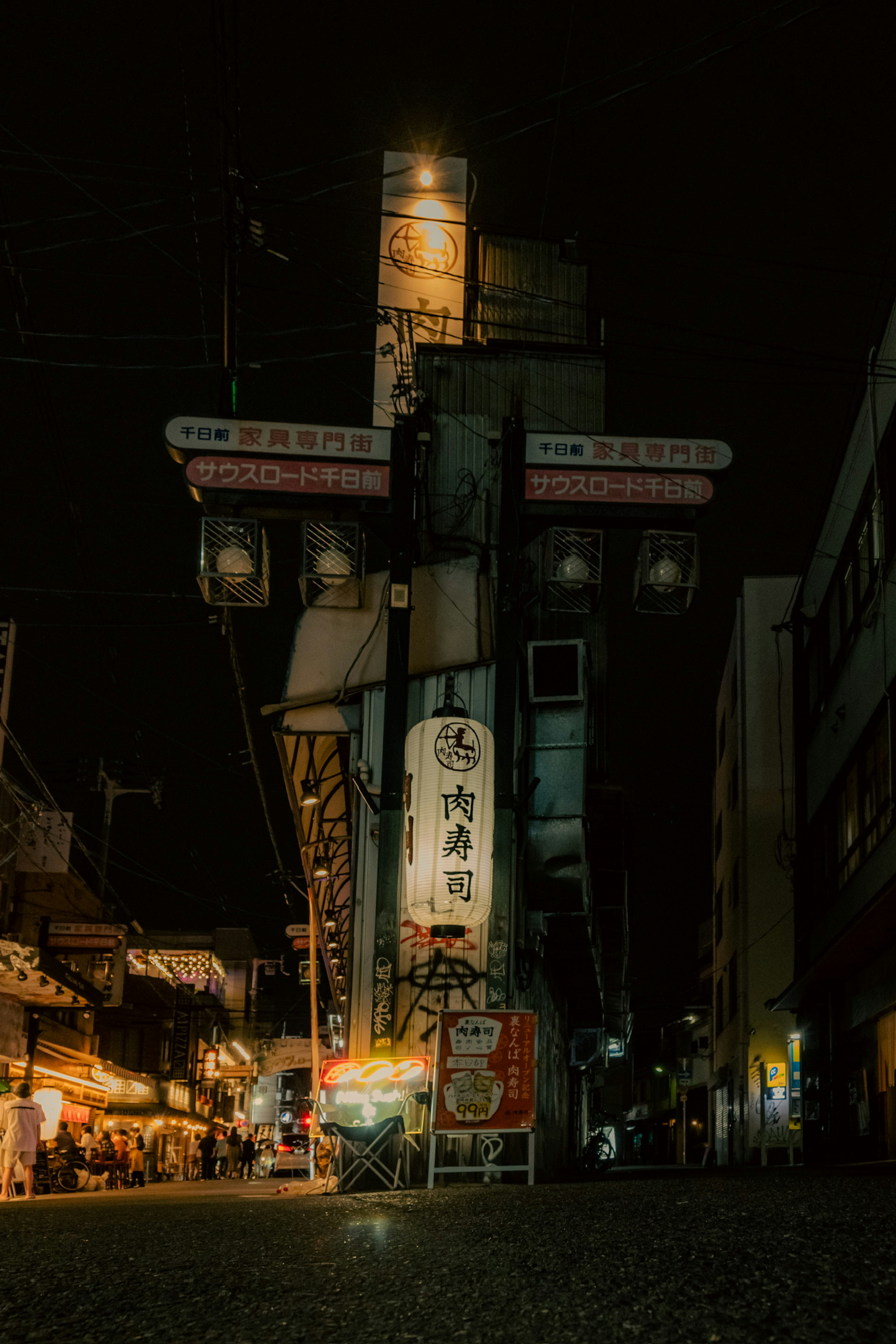 Night cityscape featuring a large sign and people