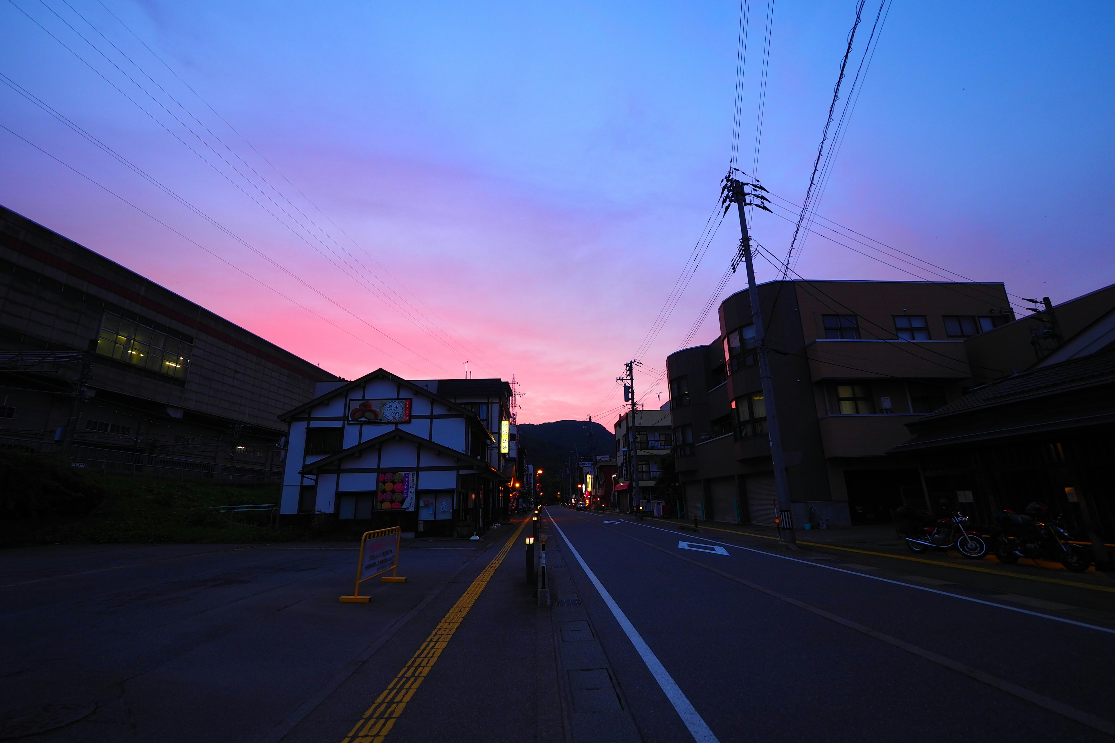 Escena de calle tranquila con cielo vibrante al atardecer