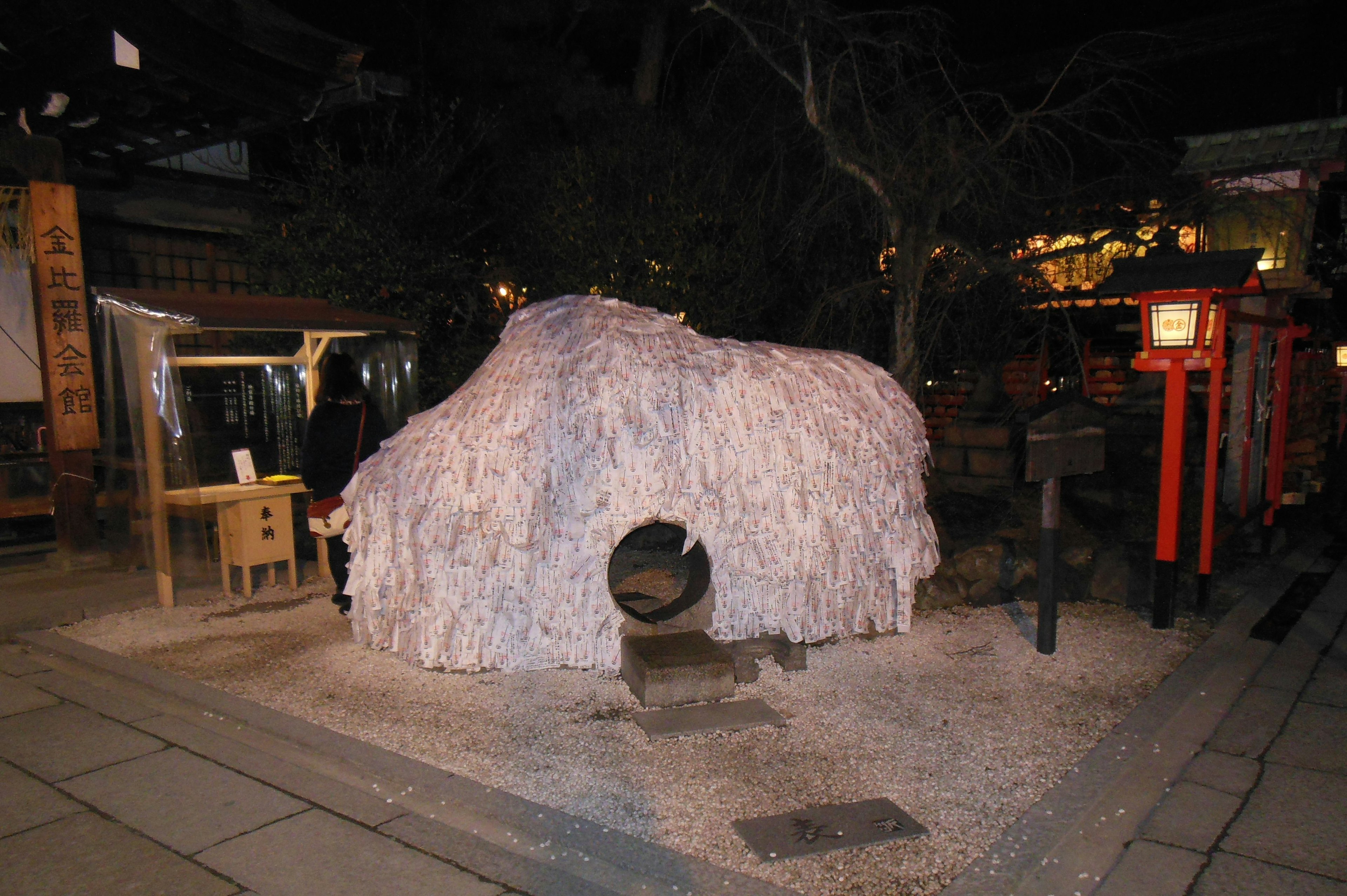 夜の桜の下にある独特な形の岩の彫刻