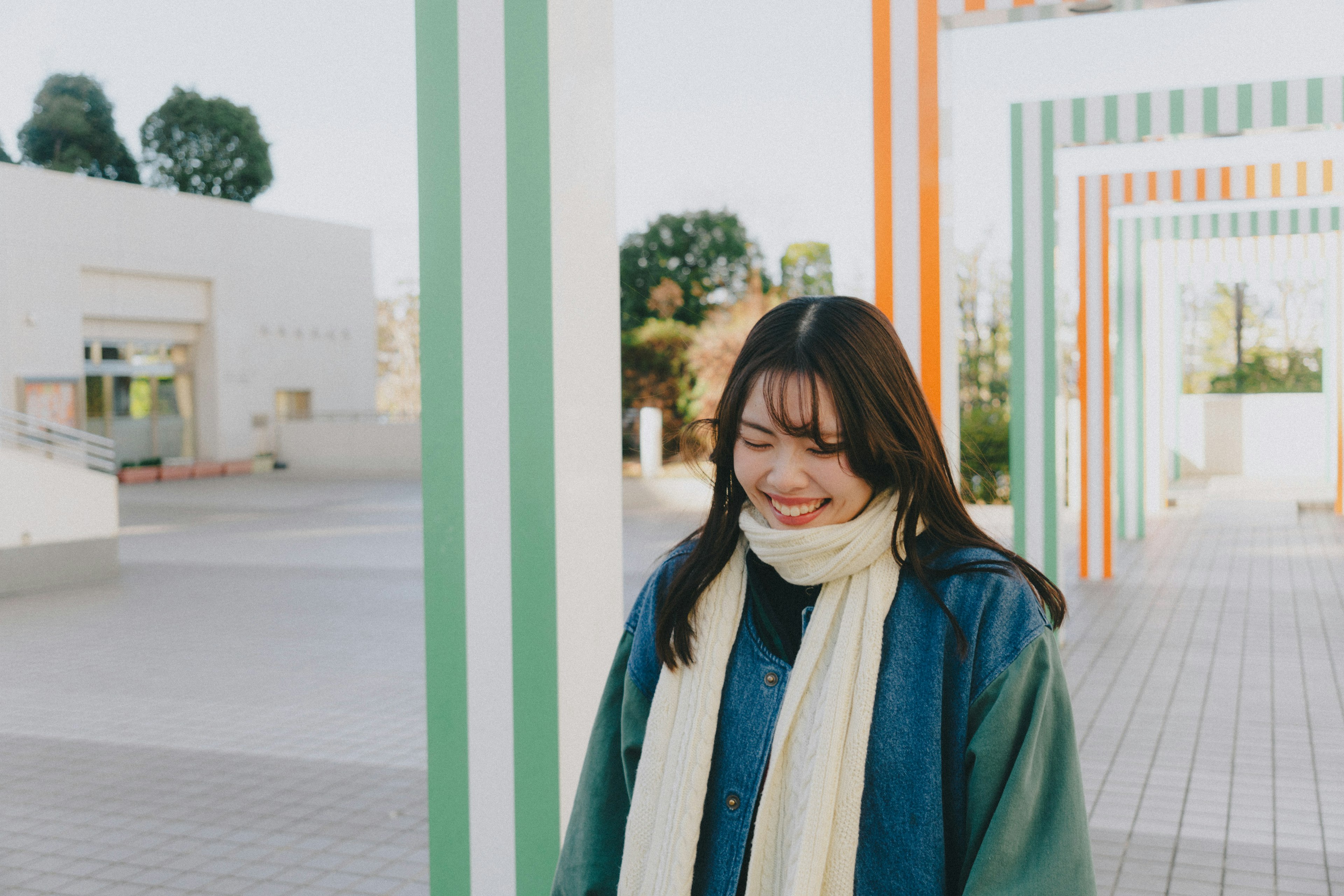 Joven mujer sonriendo entre columnas a rayas