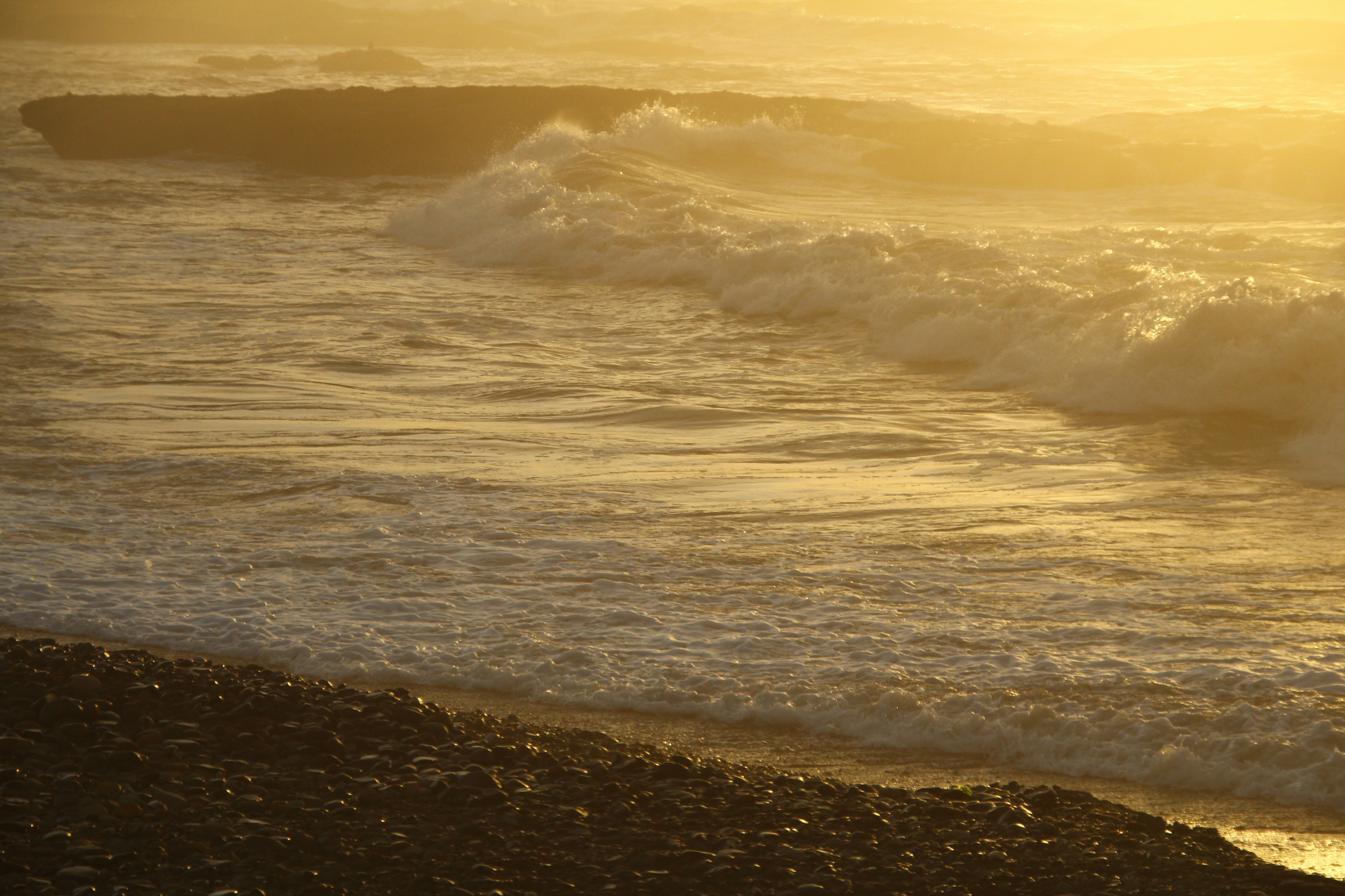 Goldene Wellen bei Sonnenuntergang mit einem Sandstrand