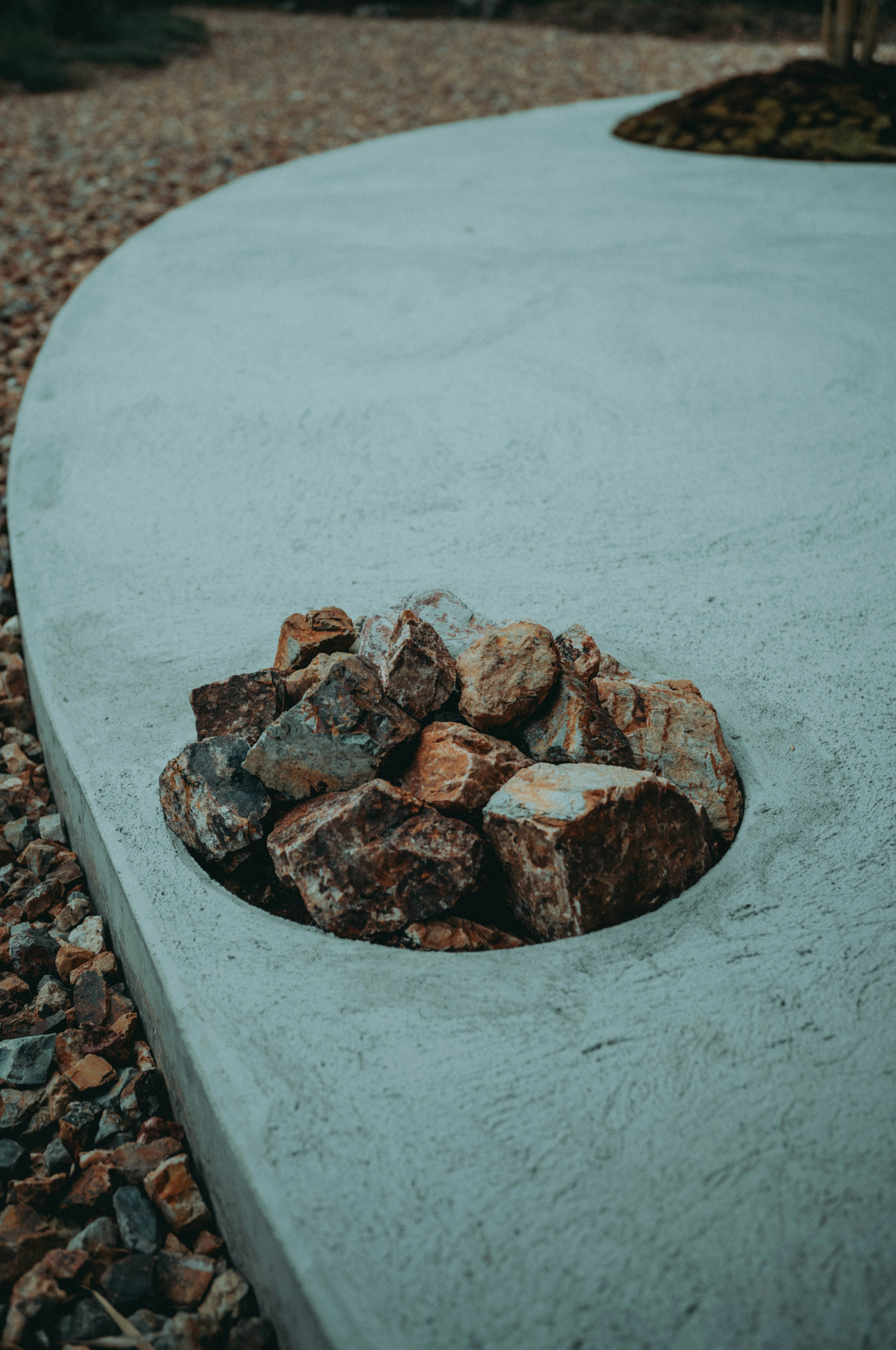 Close-up image of a pile of rocks set in a concrete edge