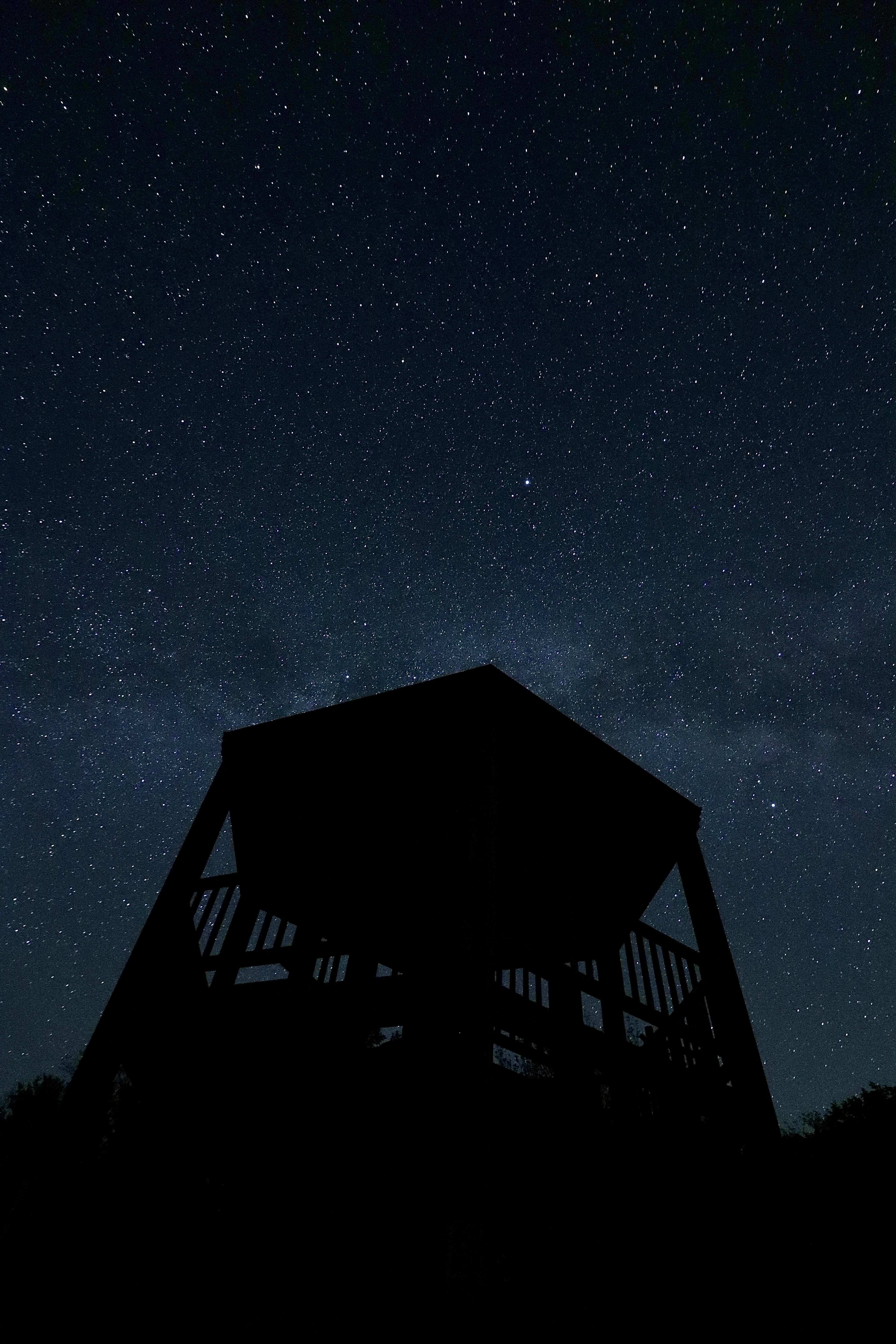 Silhouetted gazebo under a starry night sky