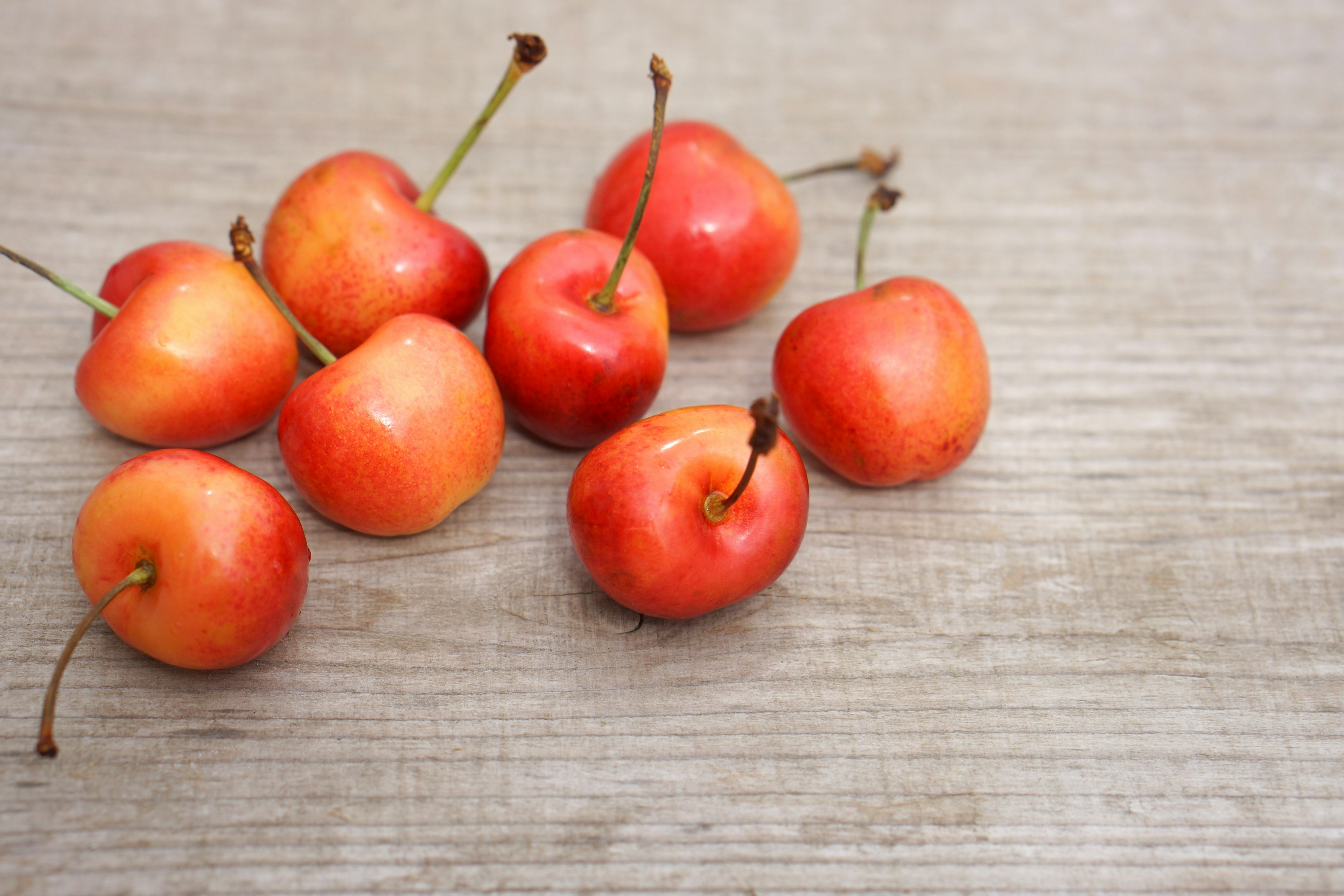 Small red apples scattered on a wooden table