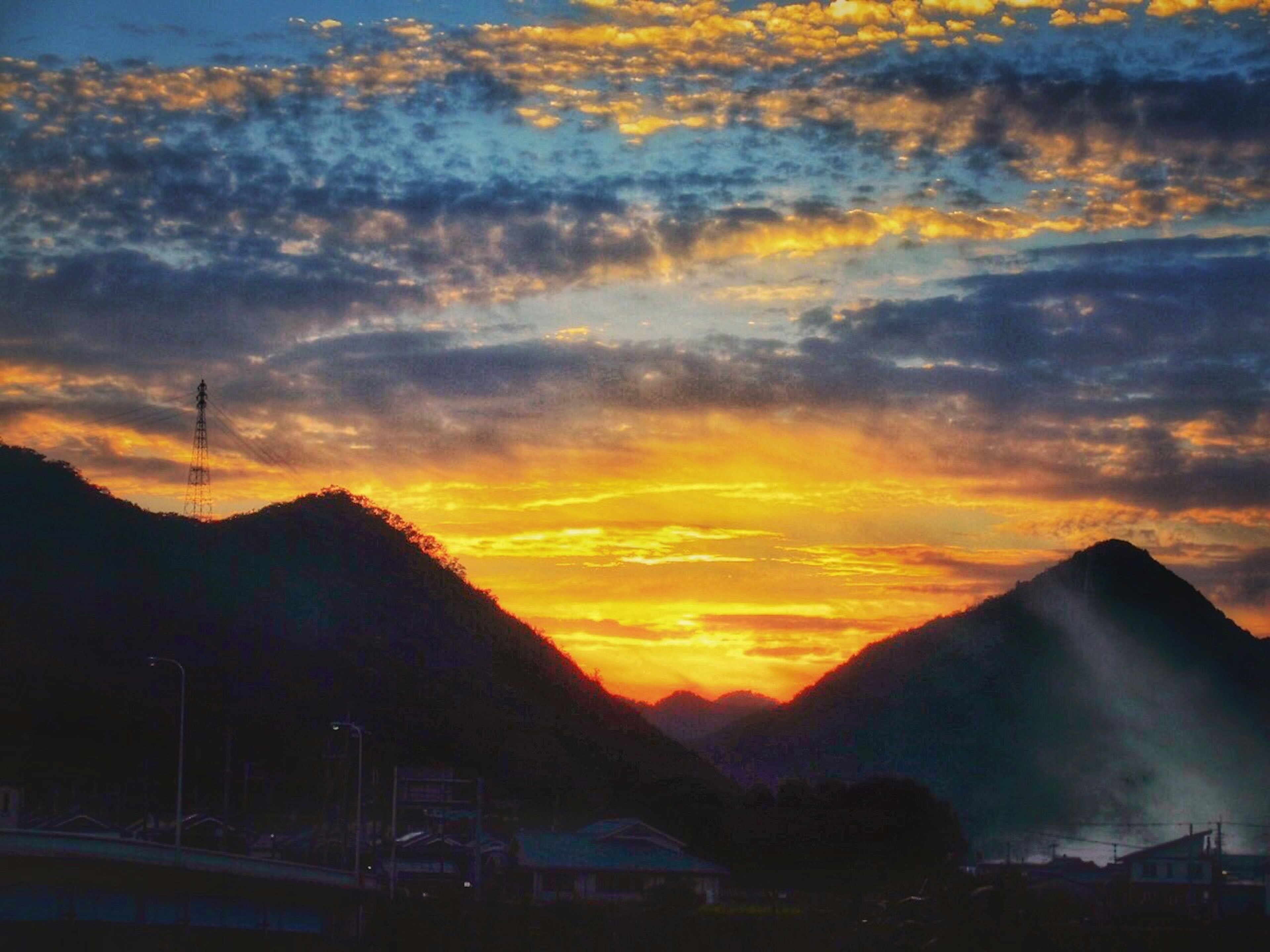 山々の間から美しい夕日が沈む風景