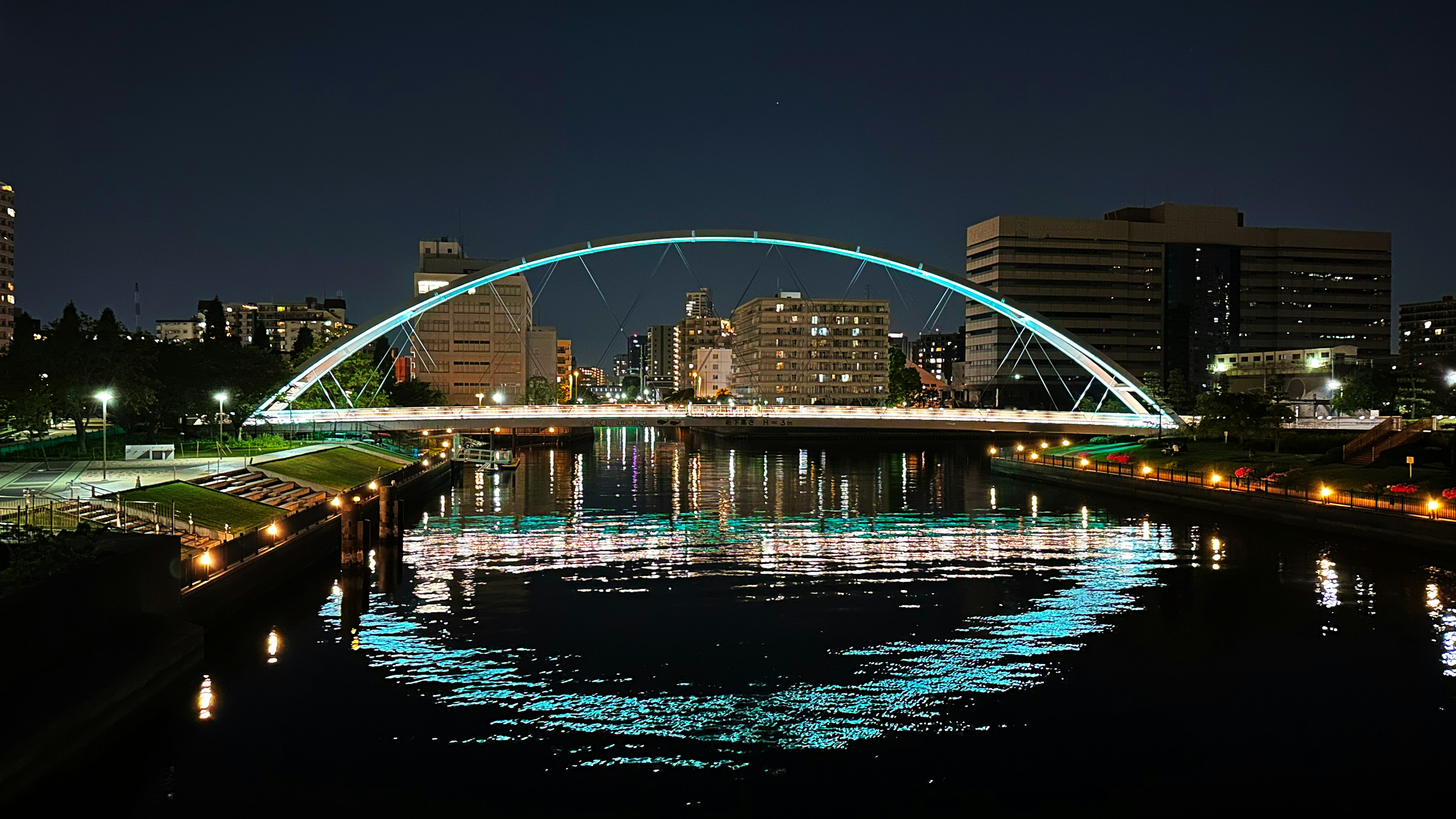 Ponte ad arco sul fiume di notte con riflessi