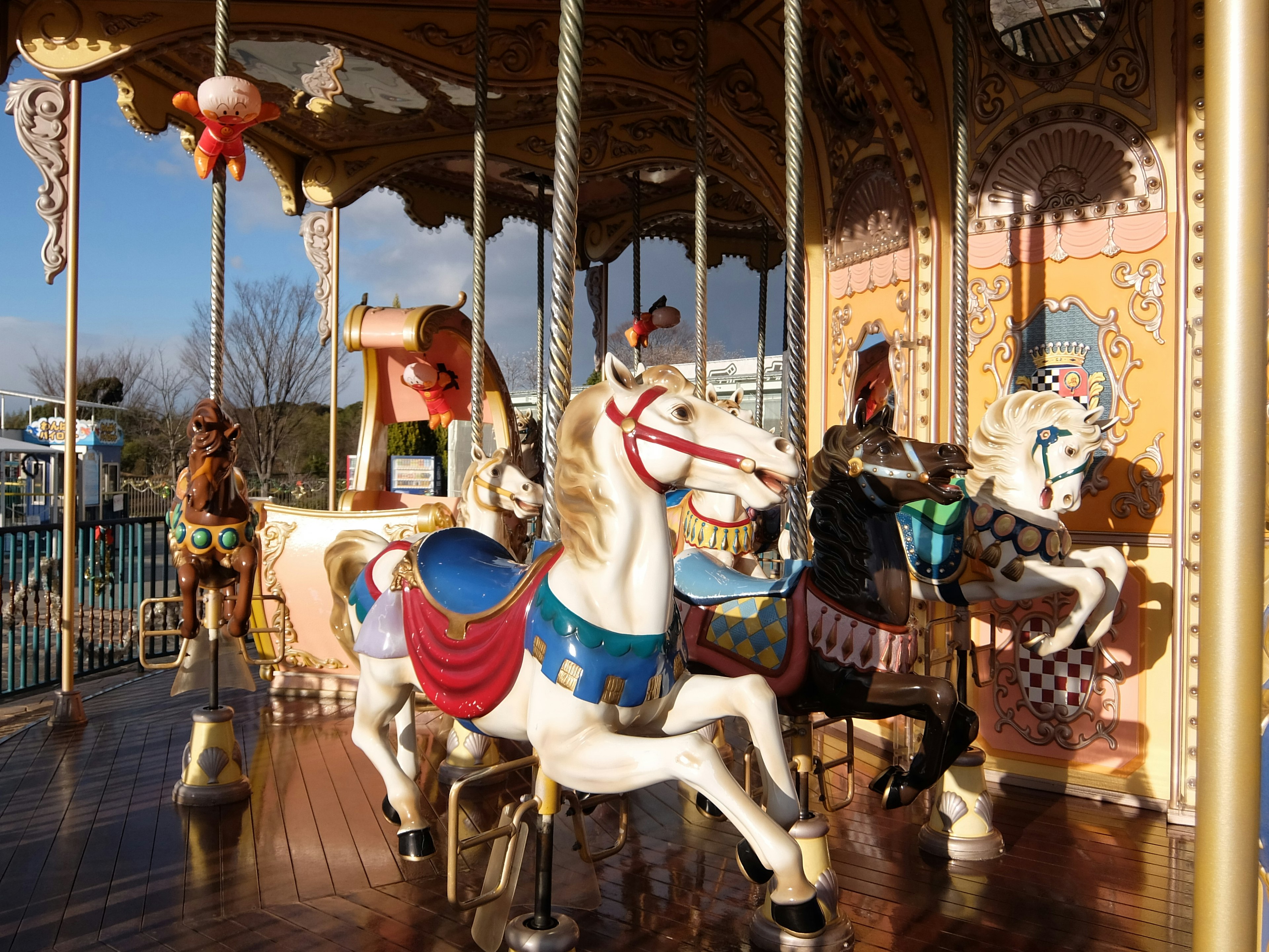 Kuda carousel berwarna-warni di latar taman hiburan yang indah