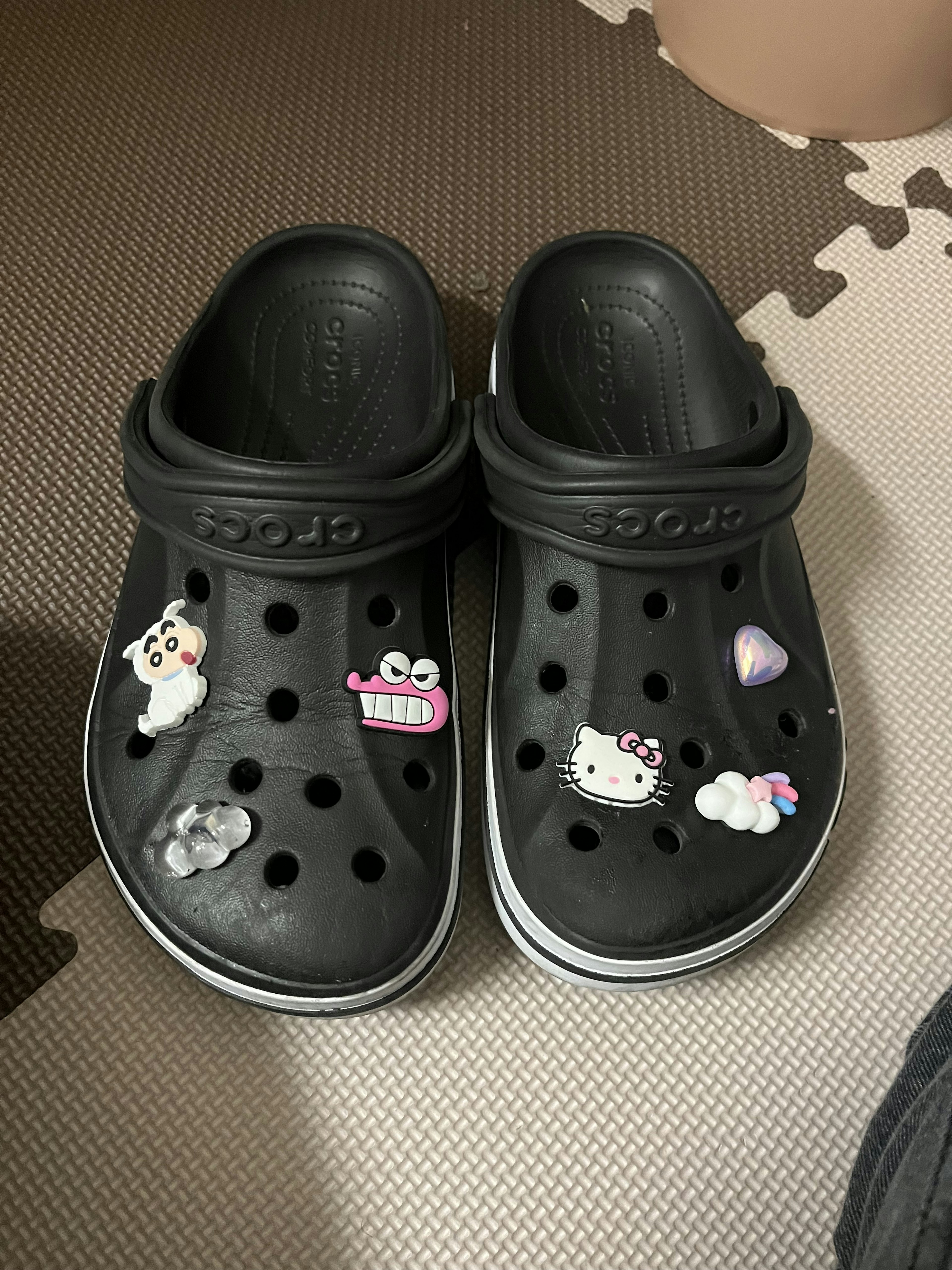 Black Crocs with custom charms featuring various characters