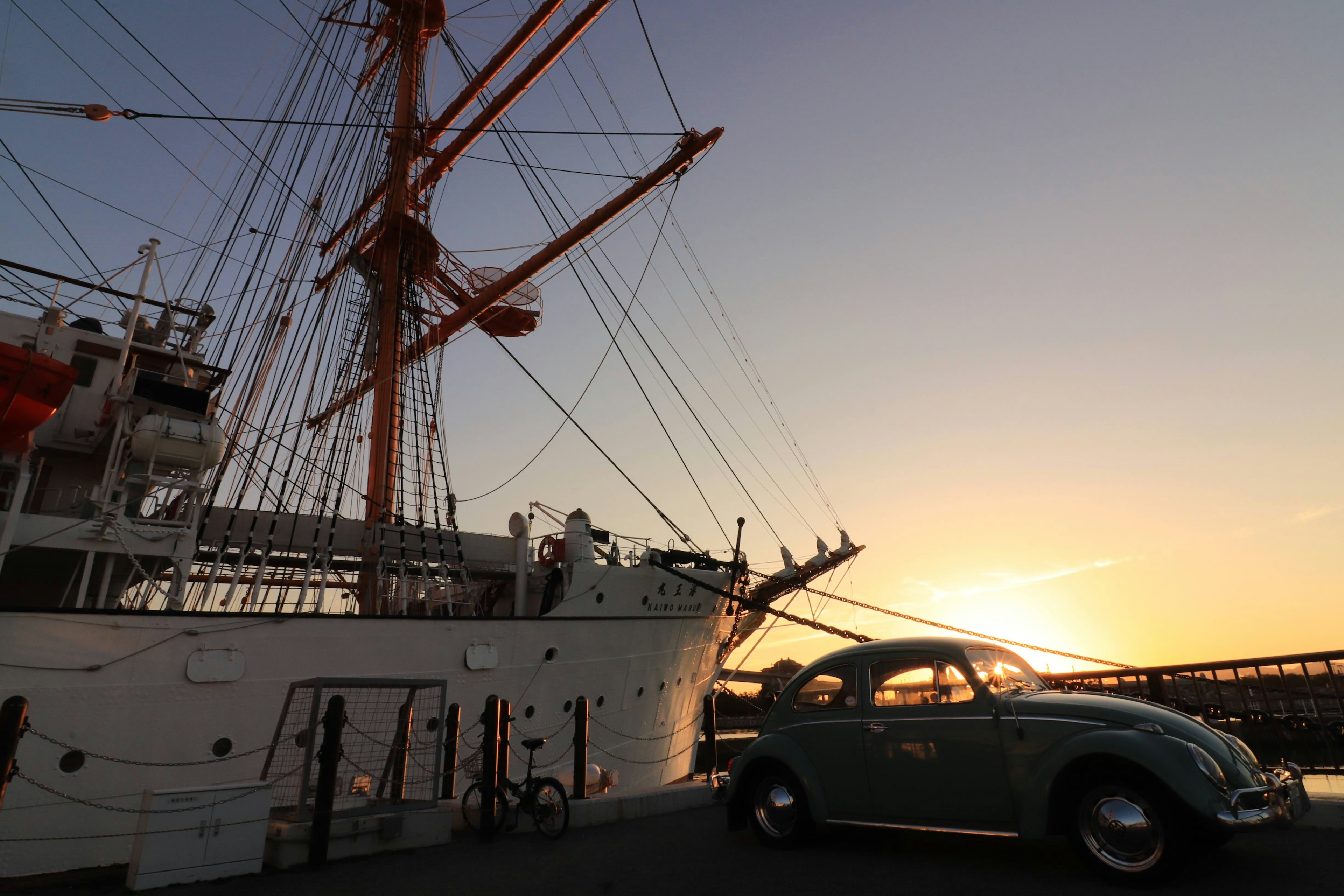 Vista panoramica di una nave e di un'auto d'epoca al tramonto