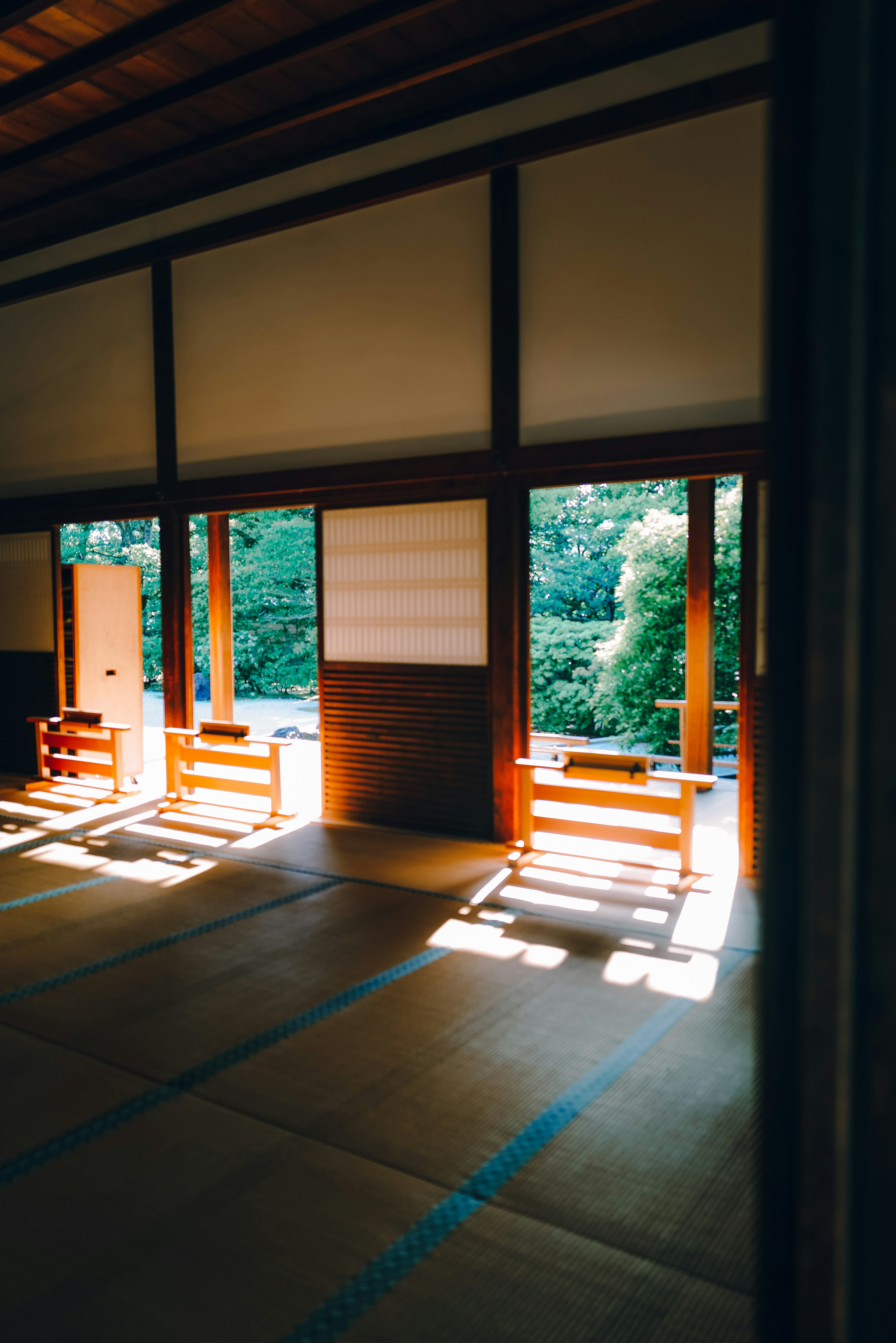 Interior ruangan Jepang tradisional dengan cahaya alami dan pemandangan hijau melalui jendela