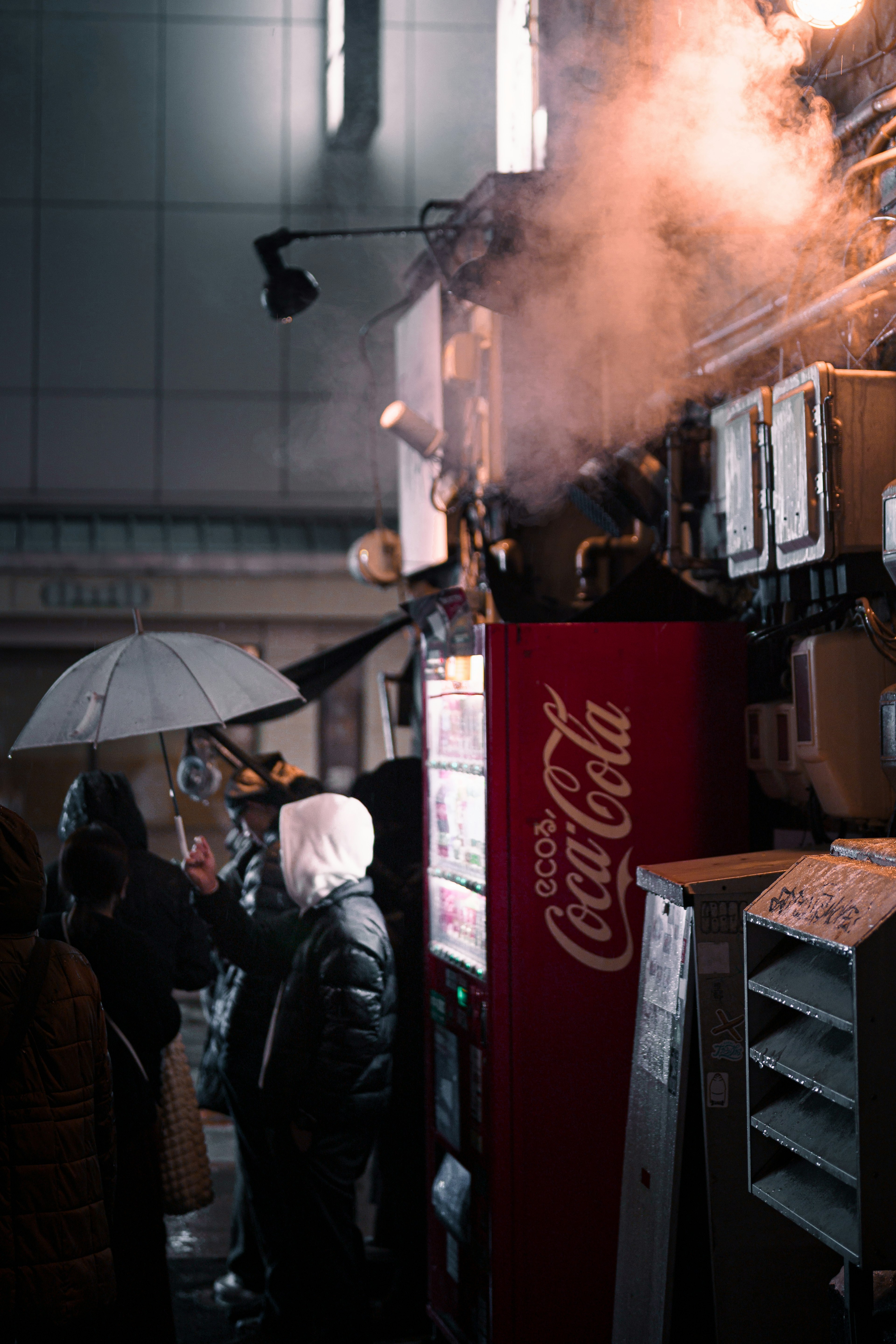 Cảnh đường phố với máy bán hàng tự động Coca-Cola và hơi nước bốc lên