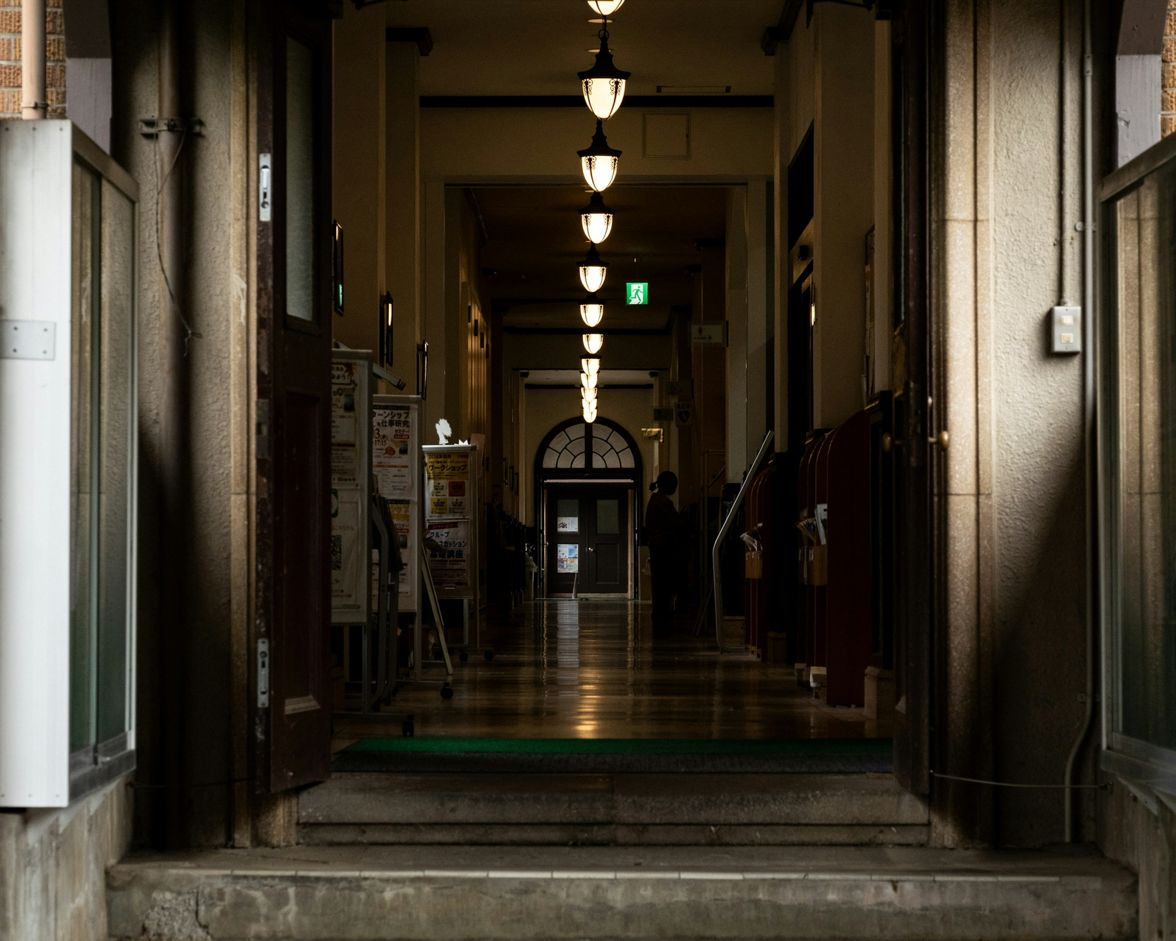 Long corridor with overhead lights and entrance doors visible