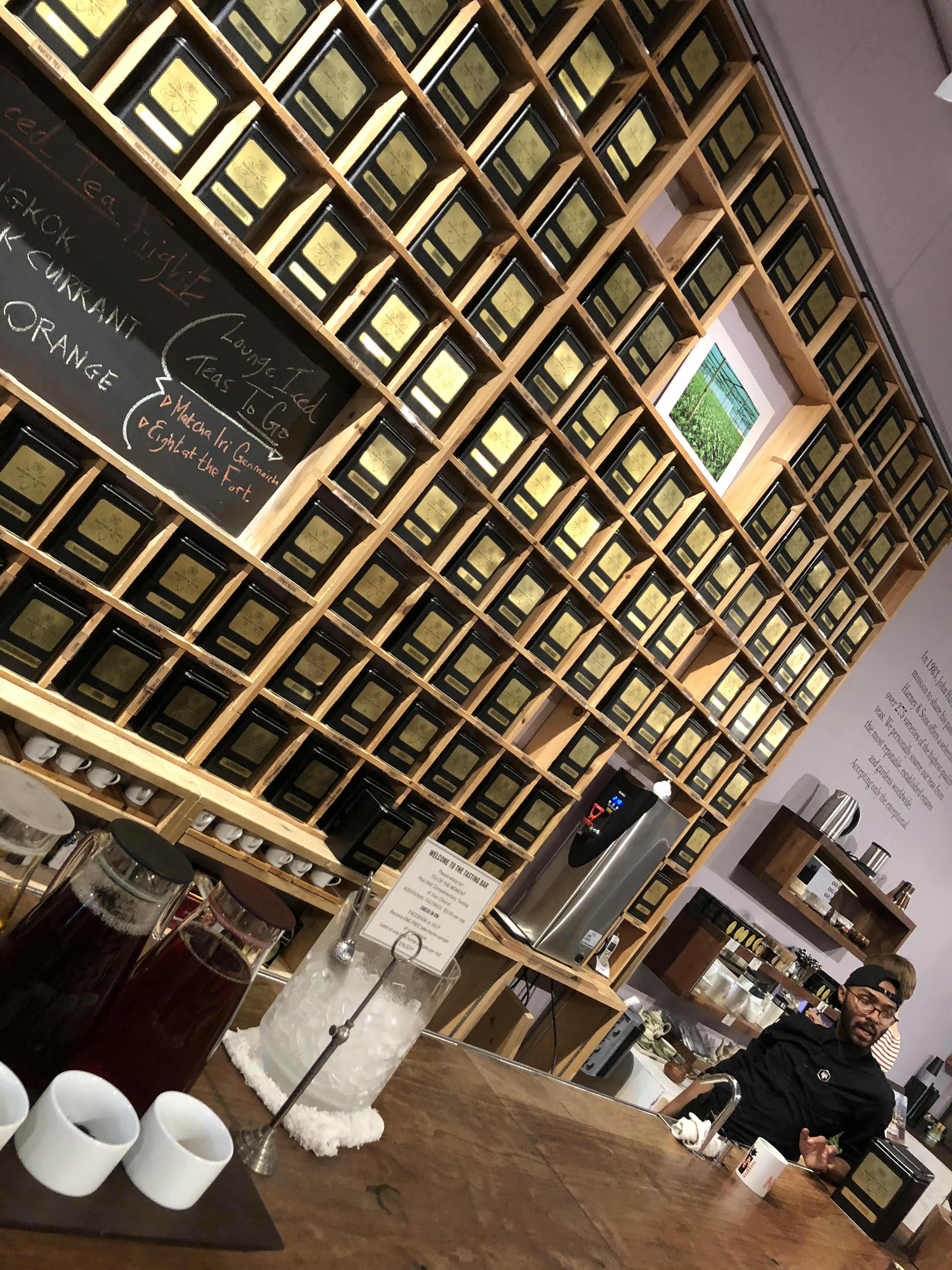 Interior of a cafe featuring a wall of tea boxes and a counter