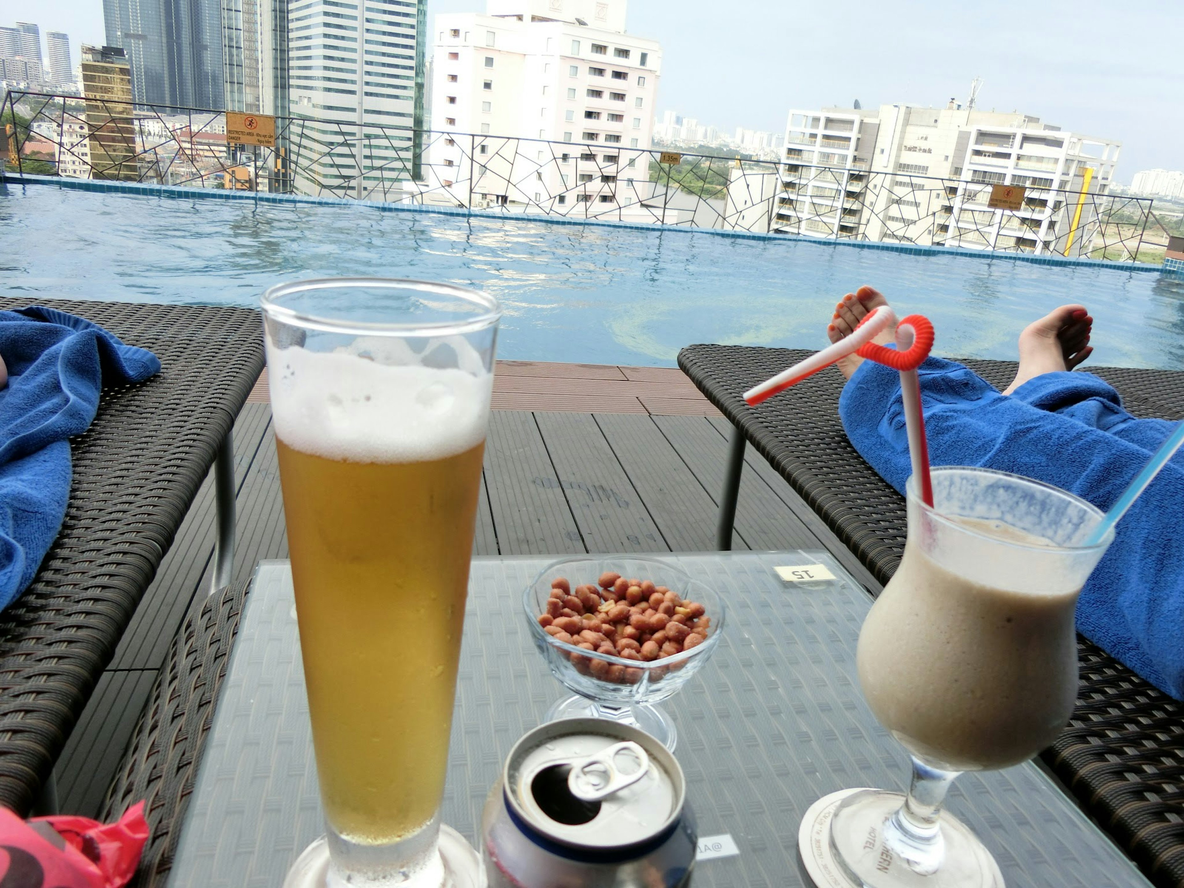 Escena relajante junto a la piscina con cerveza y cóctel junto a snacks