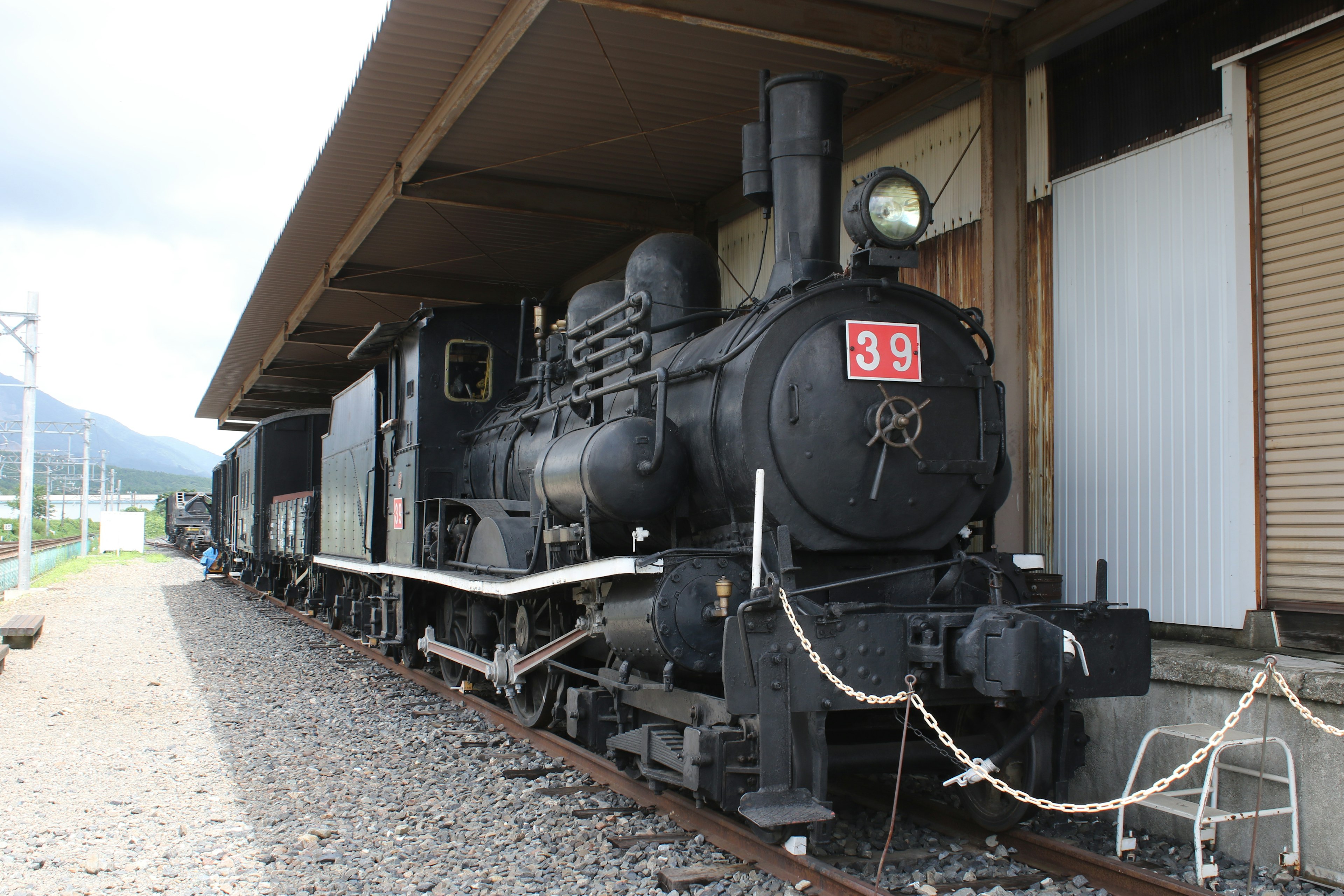 黒い蒸気機関車39号が屋根のある駅に停車中