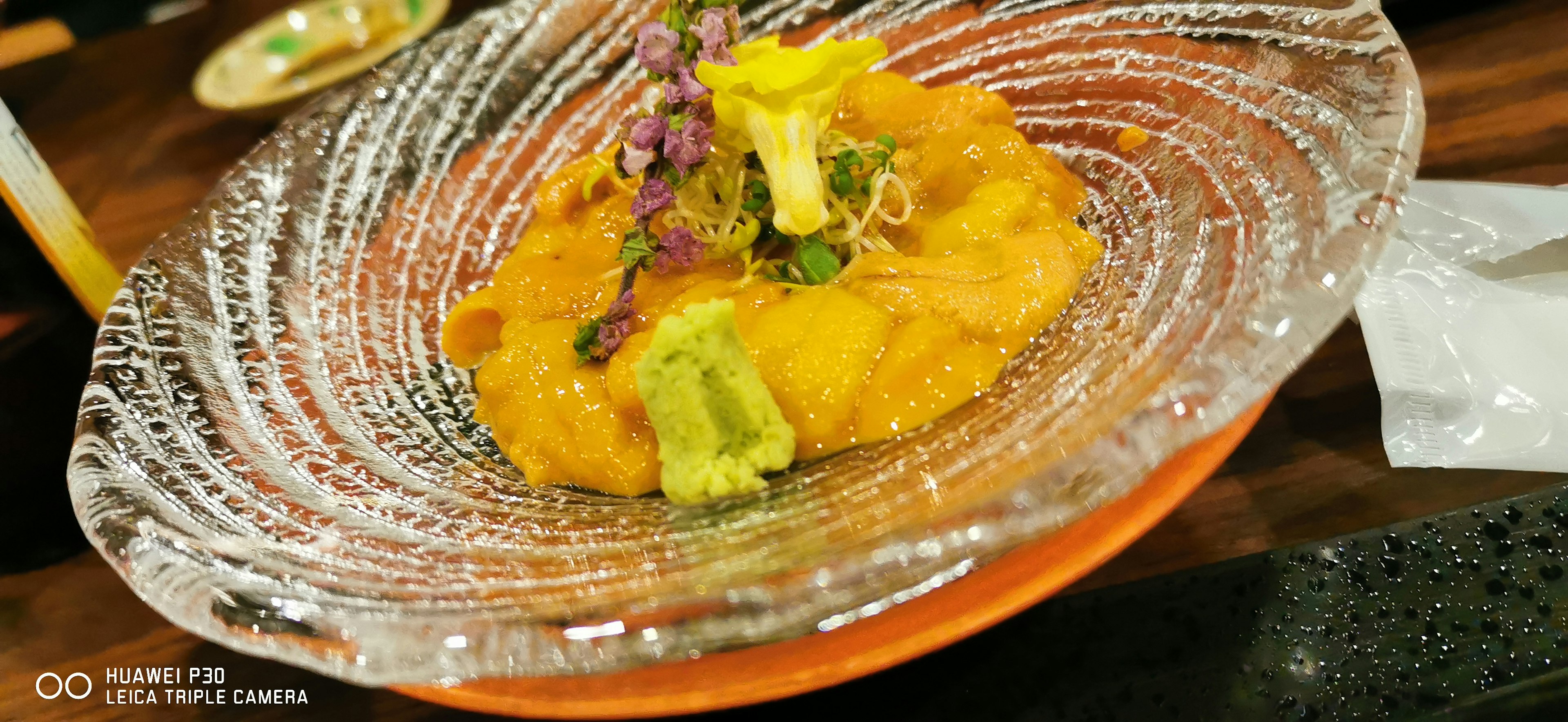 A beautifully presented tempura dish on a decorative plate featuring vibrant vegetables and garnishes