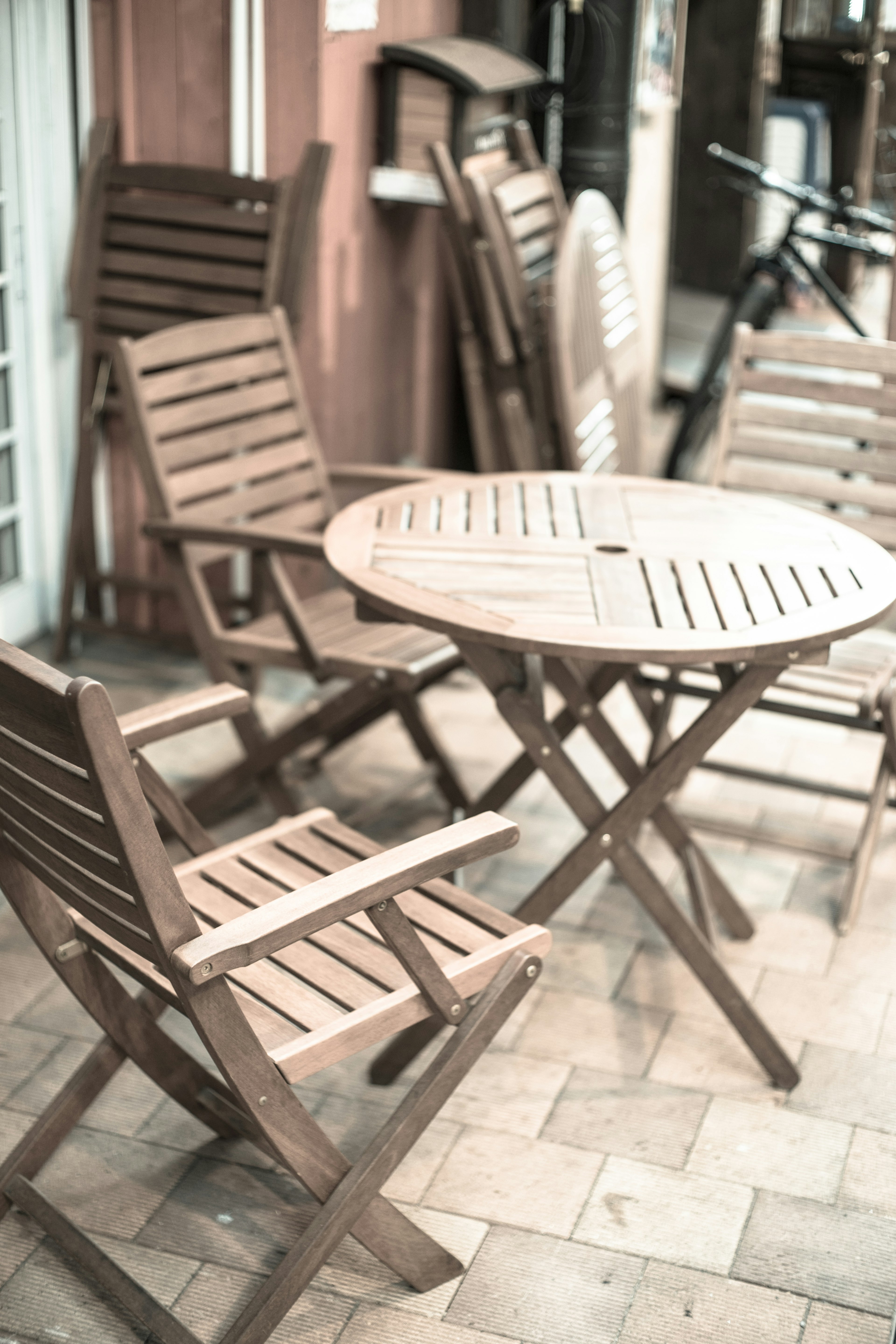 Außenbereich eines Cafés mit Holztisch und Stühlen