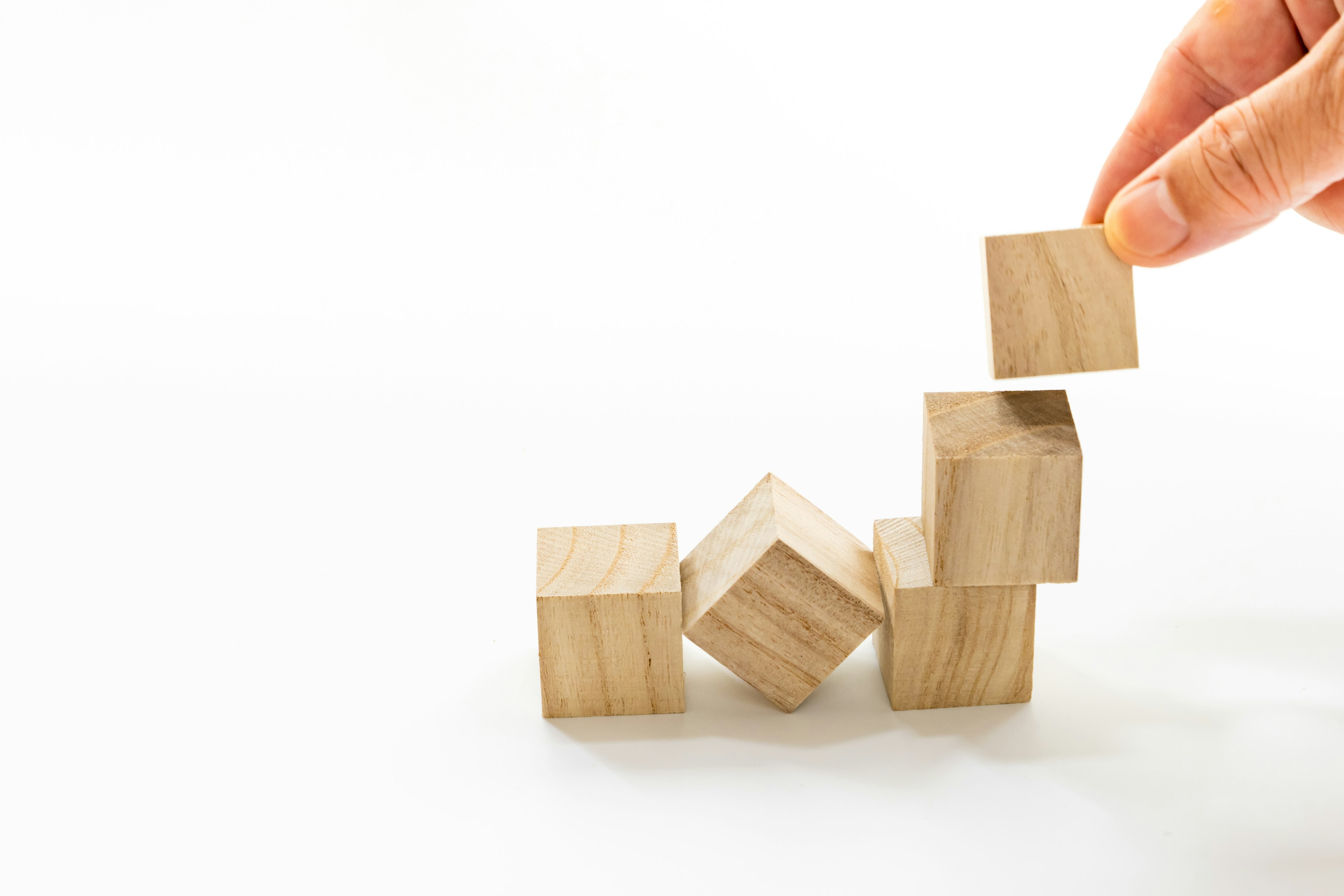 Image of a hand stacking wooden blocks