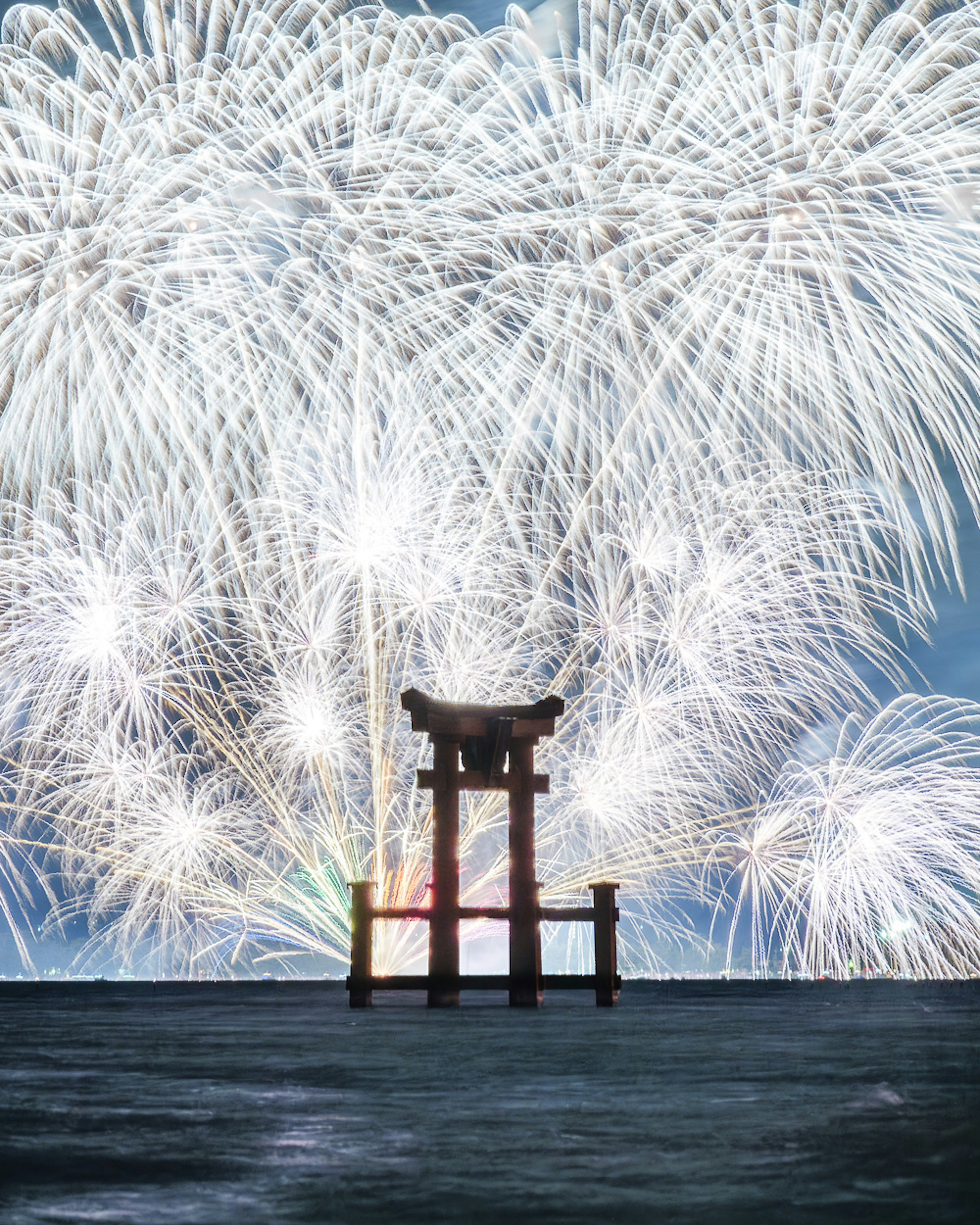 Torii-Tor auf dem Wasser mit atemberaubendem Feuerwerk