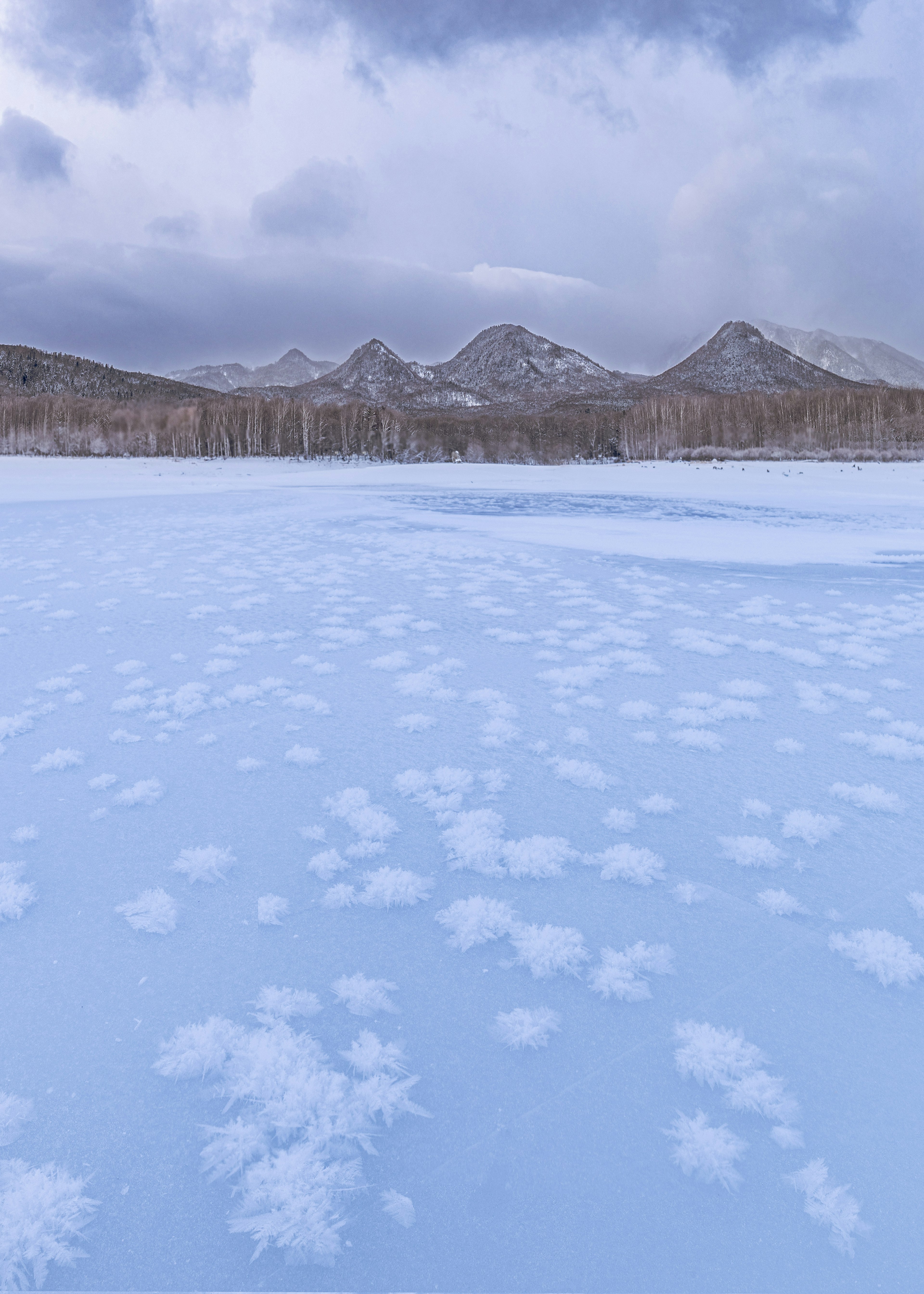 Winter landscape with snow patterns and mountains in the background