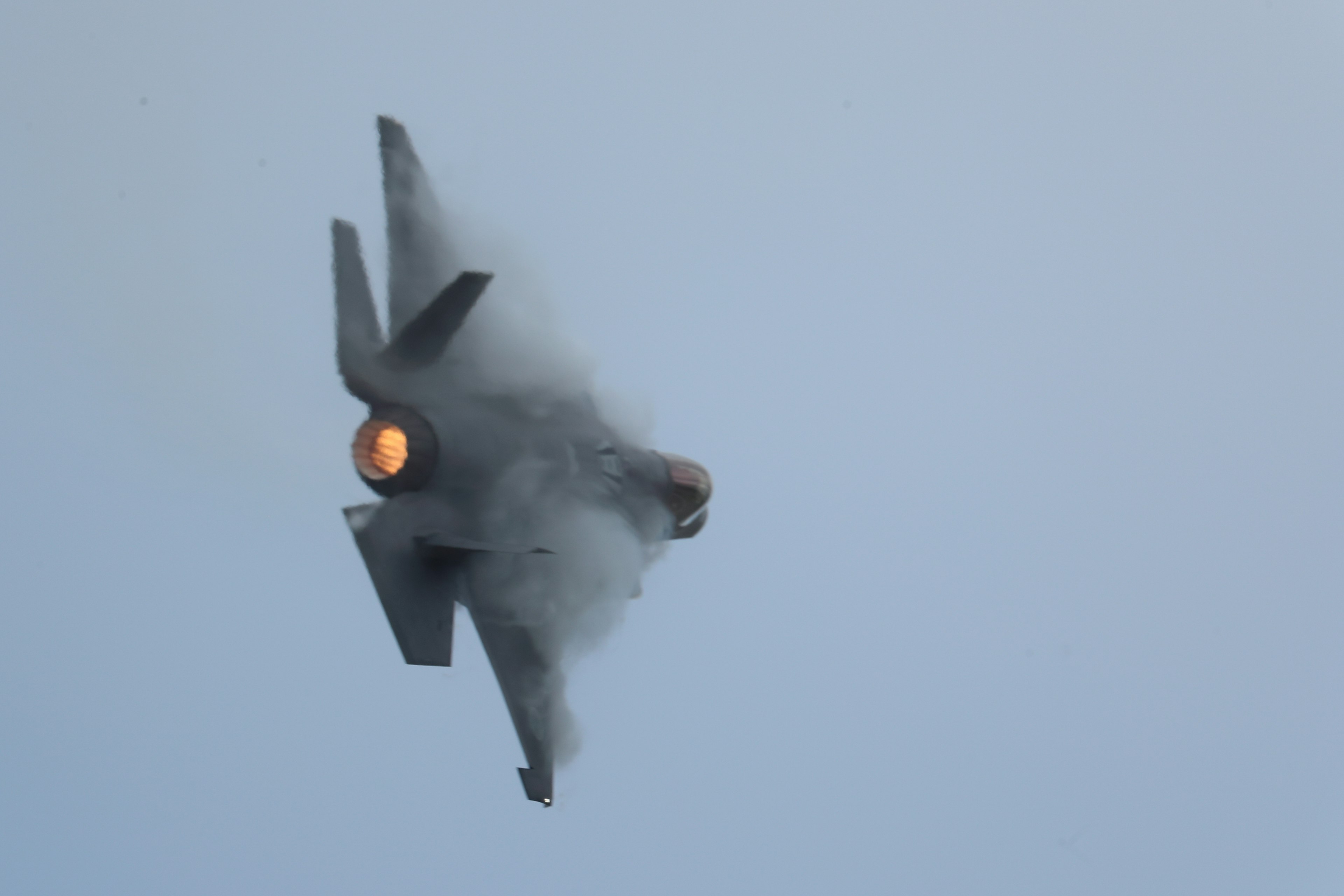 F-35 fighter jet climbing with smoke and flames