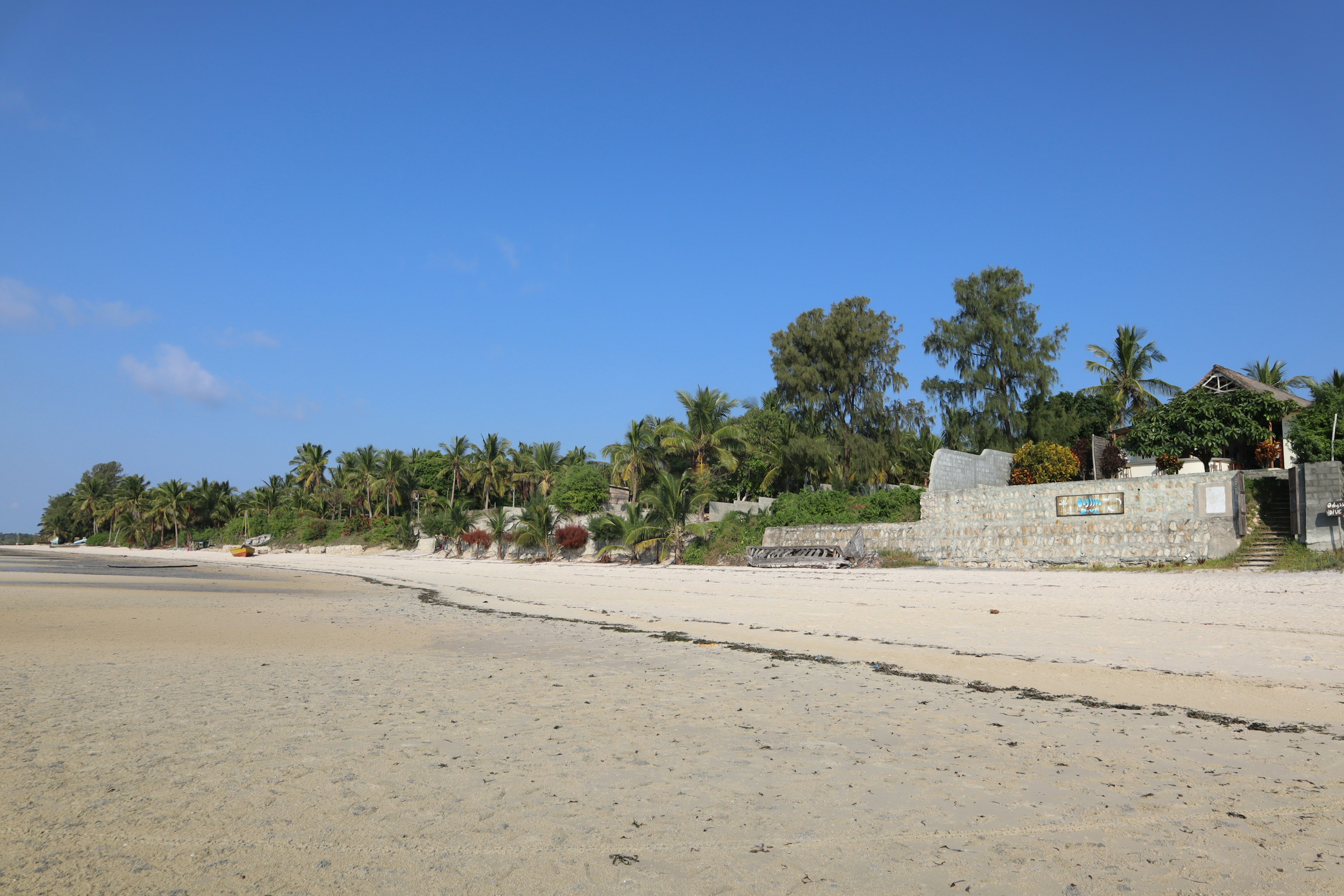 ทิวทัศน์ชายหาดที่มีท้องฟ้าสีฟ้าและชายฝั่งทราย