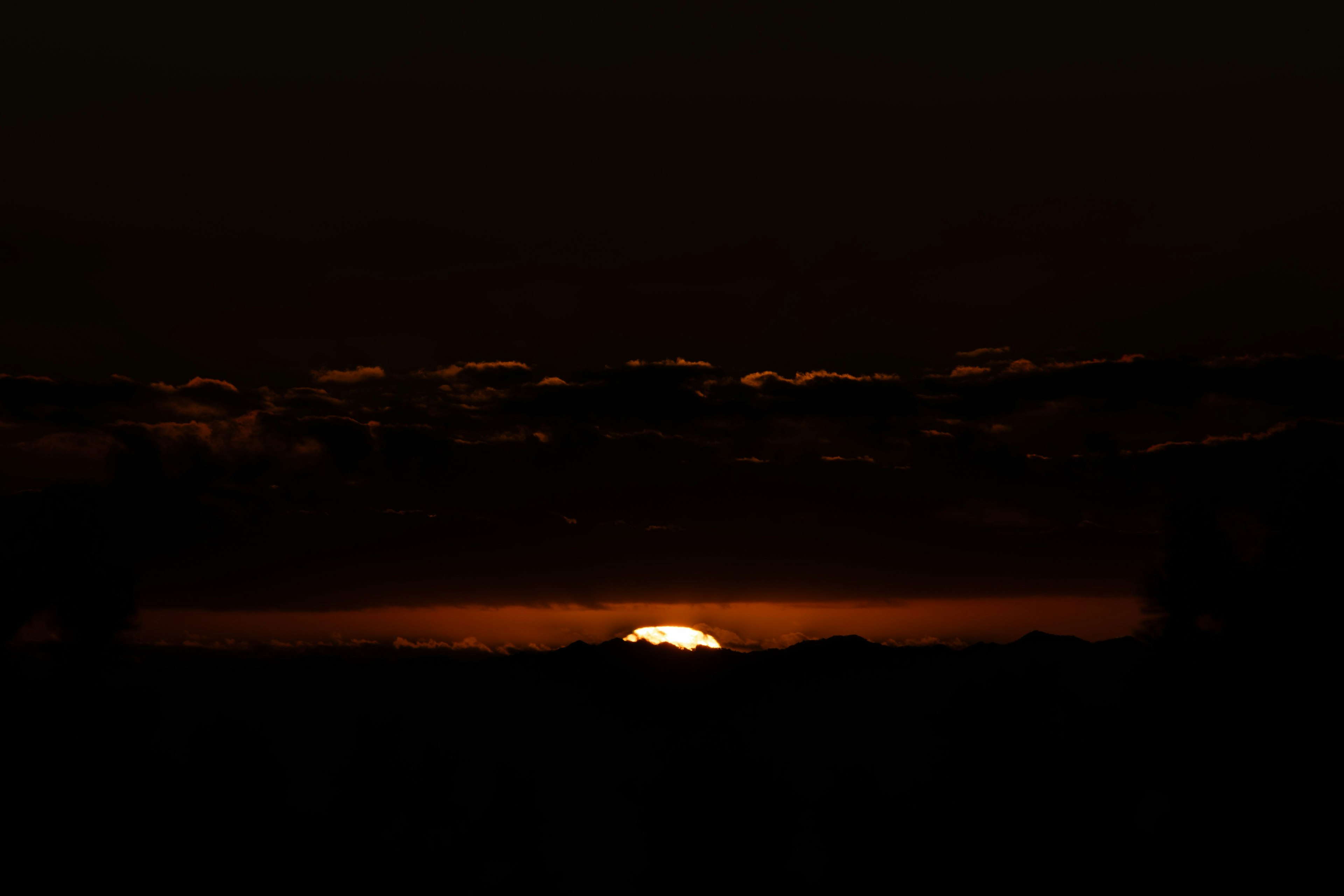 夕日が沈む風景 暗い空とオレンジ色の光