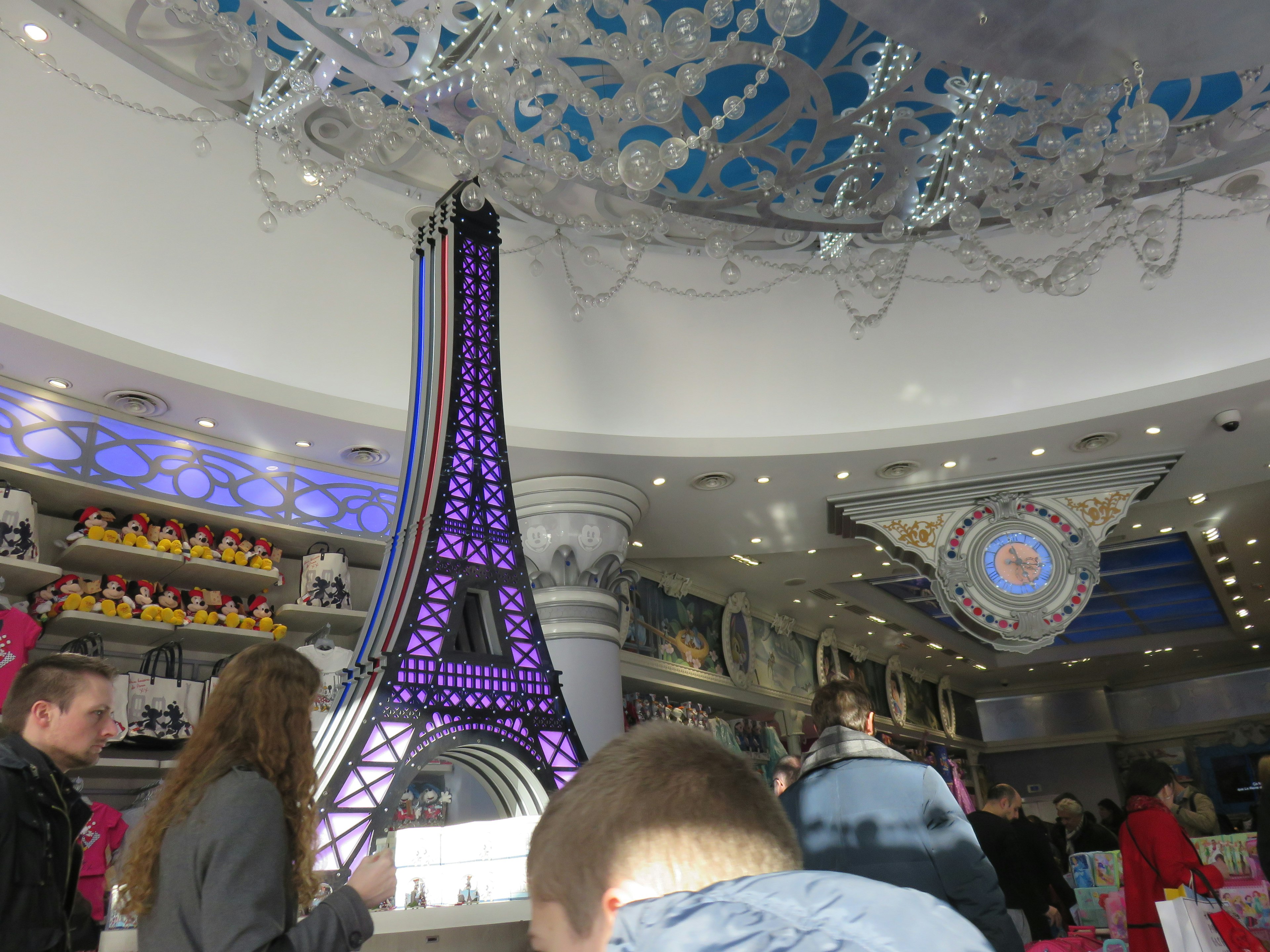 Vista interior de una tienda con una miniatura de la Torre Eiffel iluminada en púrpura