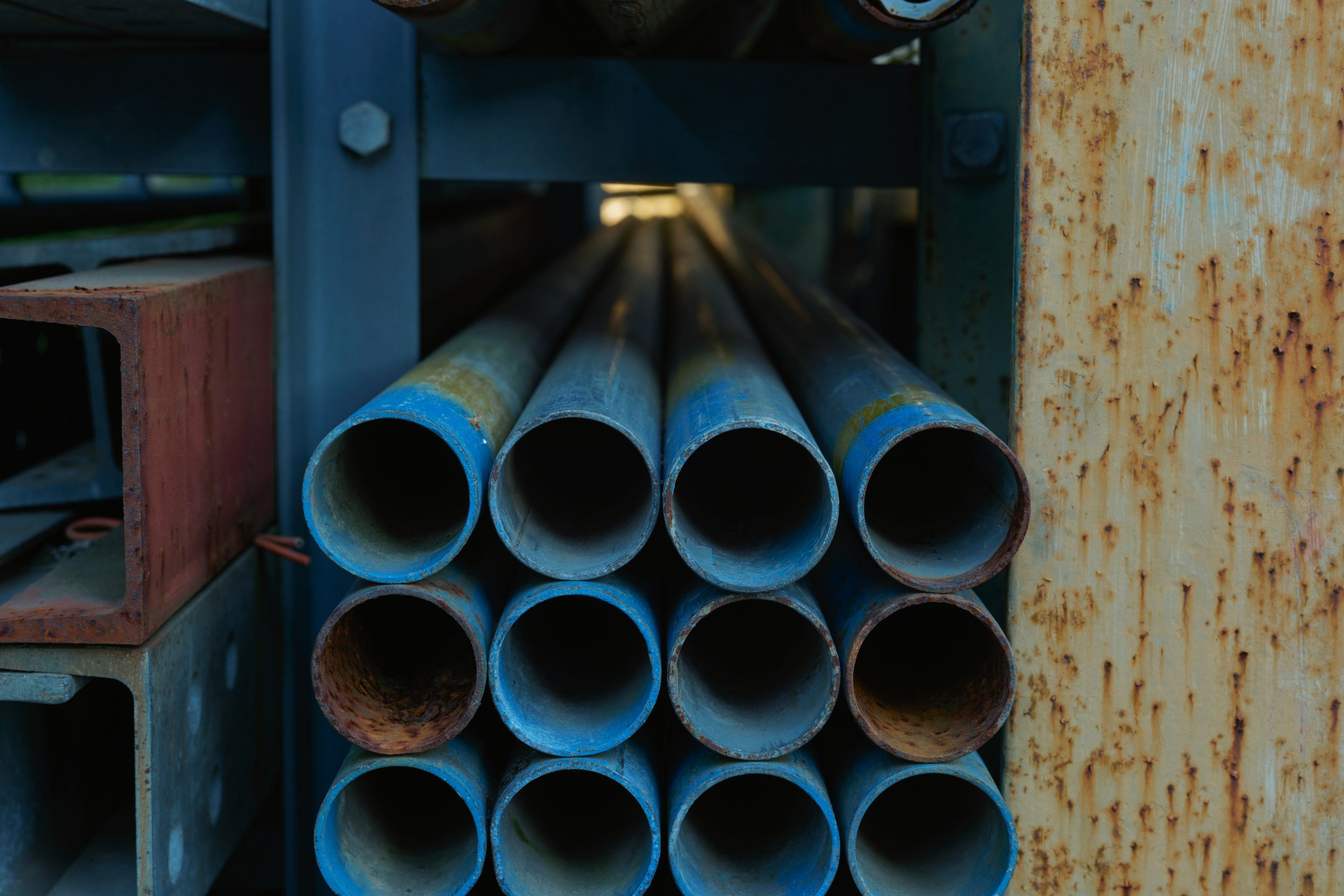 Industrial scene featuring blue pipes and rusty metal structure