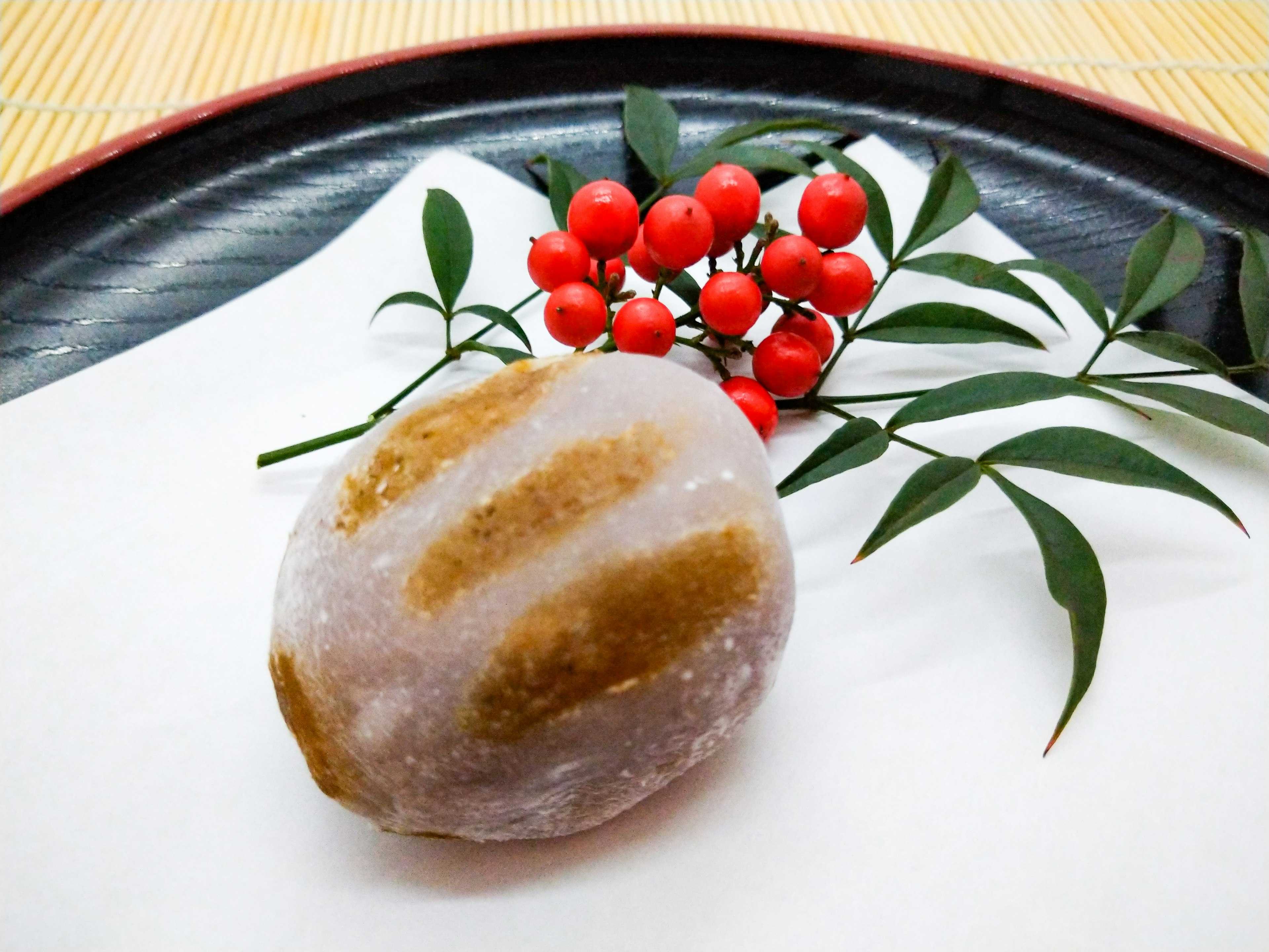 A beautiful Japanese confectionery arranged with red berries and green leaves