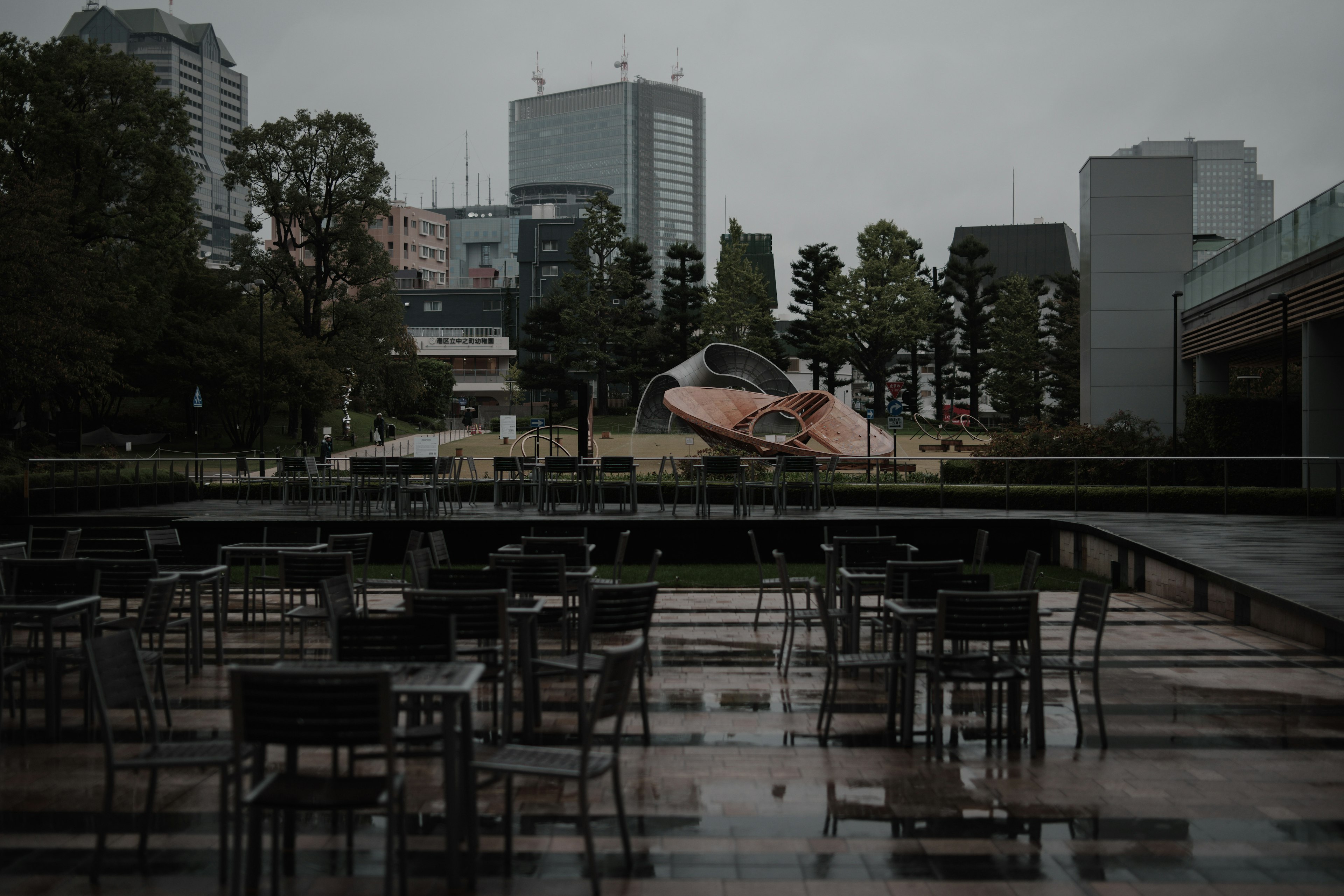 雨の日の公園にある空のテラスとモダンな建築物