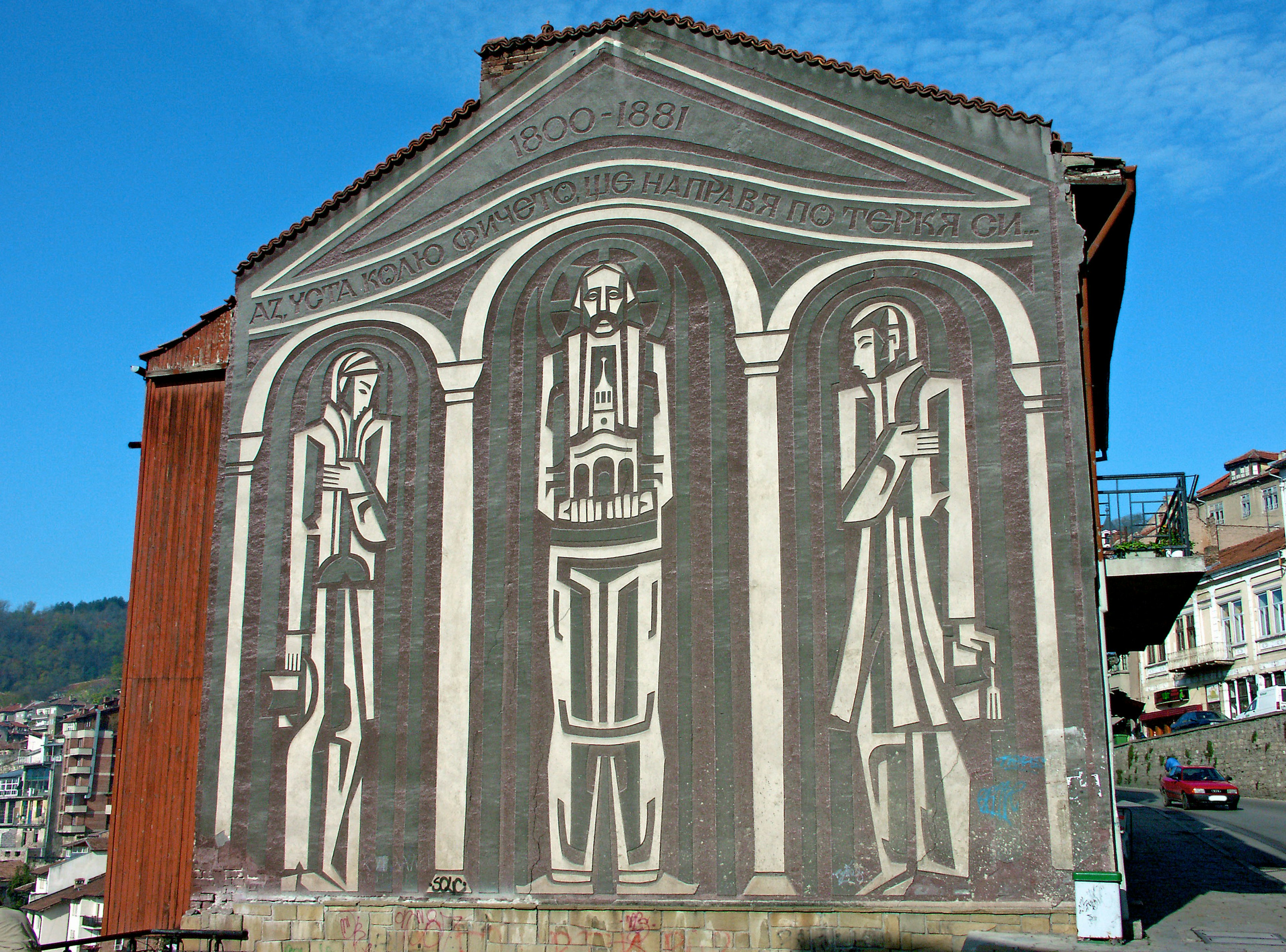 Sculptural mural depicting three figures on a building facade